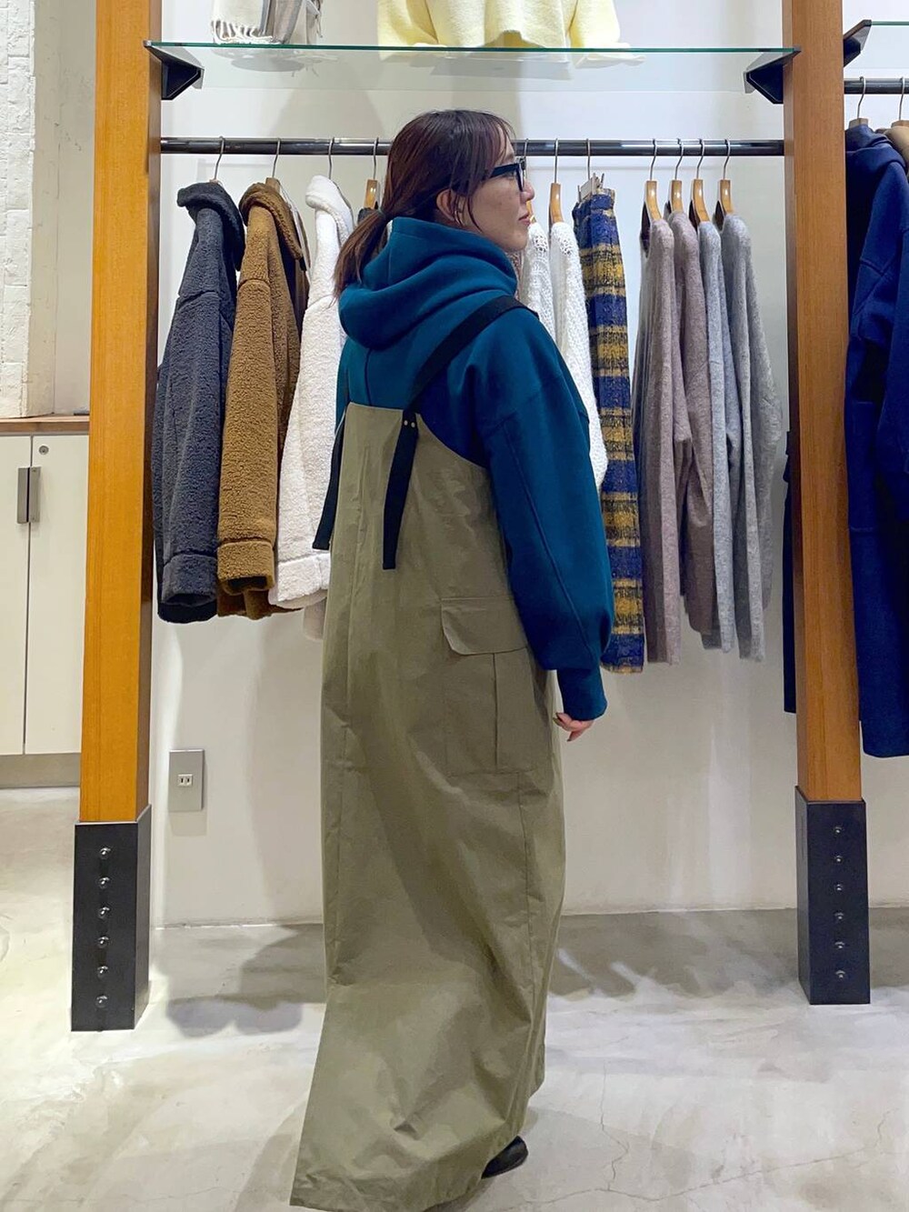 グリーン系のジャンパースカート、グリーン系のパーカーを着用したレディースの冬コーディネートの2枚目の写真