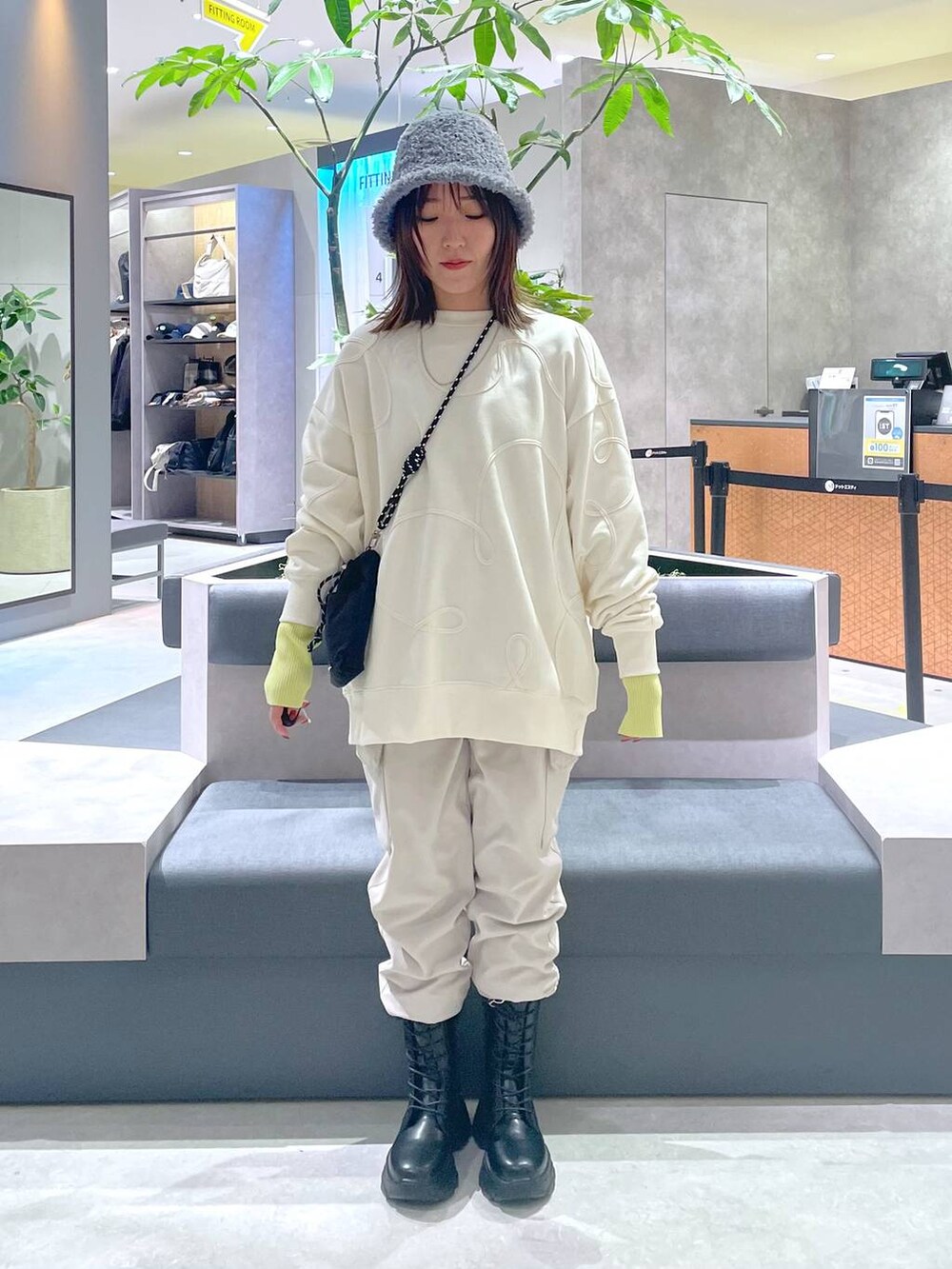 ブラック系のショルダーバッグ、ブラック系のブーツ、ベージュ系のカーゴパンツを着用したレディースの冬コーディネートの5枚目の写真