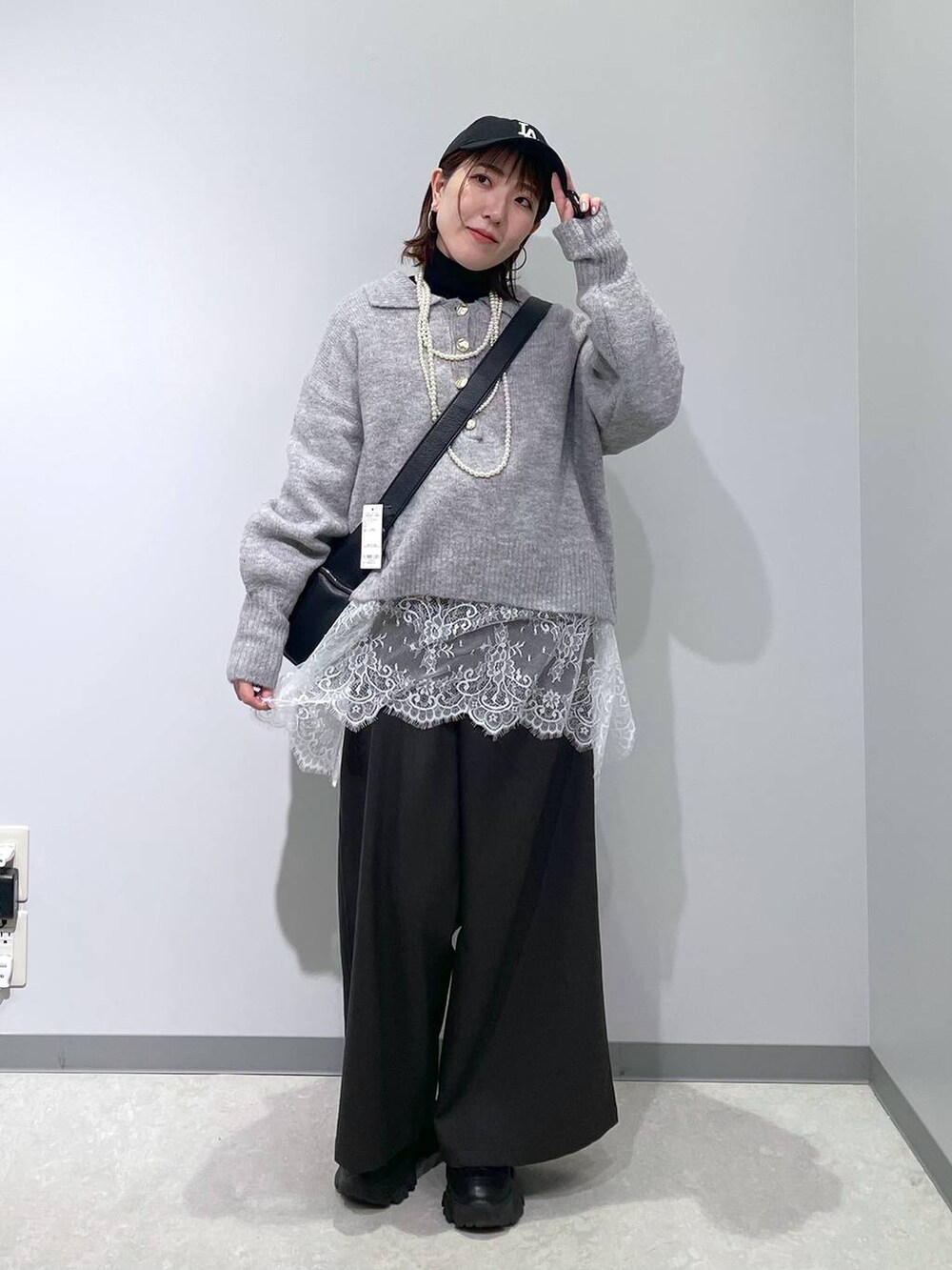 ブラック系のニット/セーター、グレー系のその他パンツ、ホワイト系のTシャツ/カットソーを着用したレディースの冬コーディネートの4枚目の写真