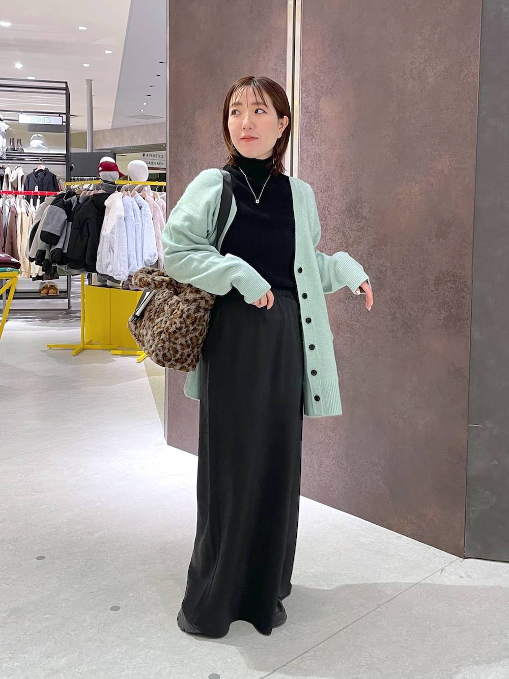 ブラック系のスカート、ブラック系のニット/セーター、その他のトートバッグを着用したレディースの冬コーディネートの3枚目の写真