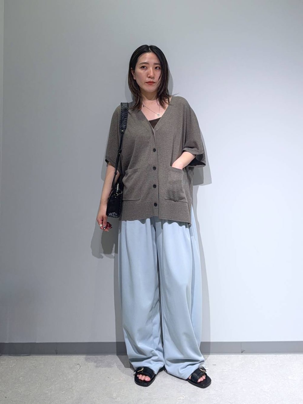 ブラウン系のカーディガン/ボレロ、ブラック系のサンダル、ブルー系のスウェットパンツを着用したレディースの夏コーディネートの3枚目の写真
