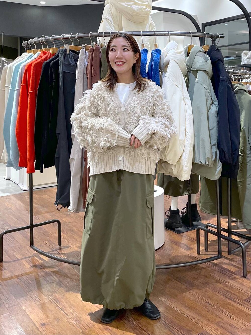 ホワイト系のTシャツ/カットソー、グリーン系のスカート、ホワイト系のカーディガン/ボレロを着用したレディースの冬コーディネートの4枚目の写真