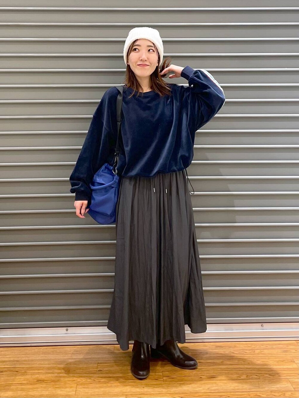 グレー系のその他パンツ、ブラウン系のブーツ、ブルー系のショルダーバッグを着用したレディースの冬コーディネートの3枚目の写真