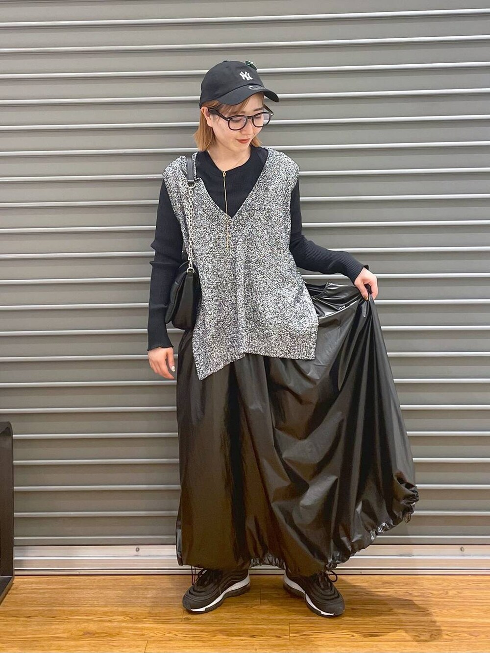 ブラック系のショルダーバッグ、ブラック系のベスト、ブラック系のTシャツ/カットソーを着用したレディースの春コーディネートの4枚目の写真