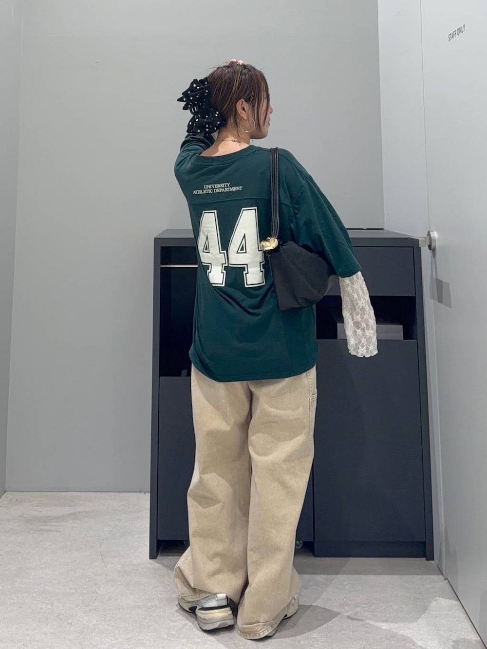 グリーン系のTシャツ/カットソー、ブラック系のショルダーバッグ、ベージュ系のデニムパンツを着用したレディースの夏コーディネートの3枚目の写真