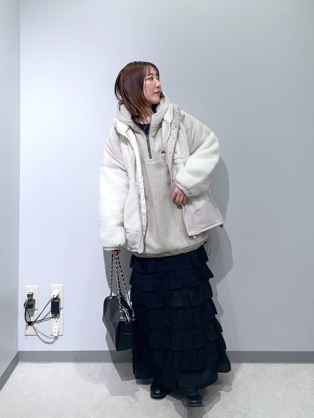 ベージュ系のその他アウター、ブラック系のスカート、ベージュ系のパーカーを着用したレディースの秋コーディネートの2枚目の写真