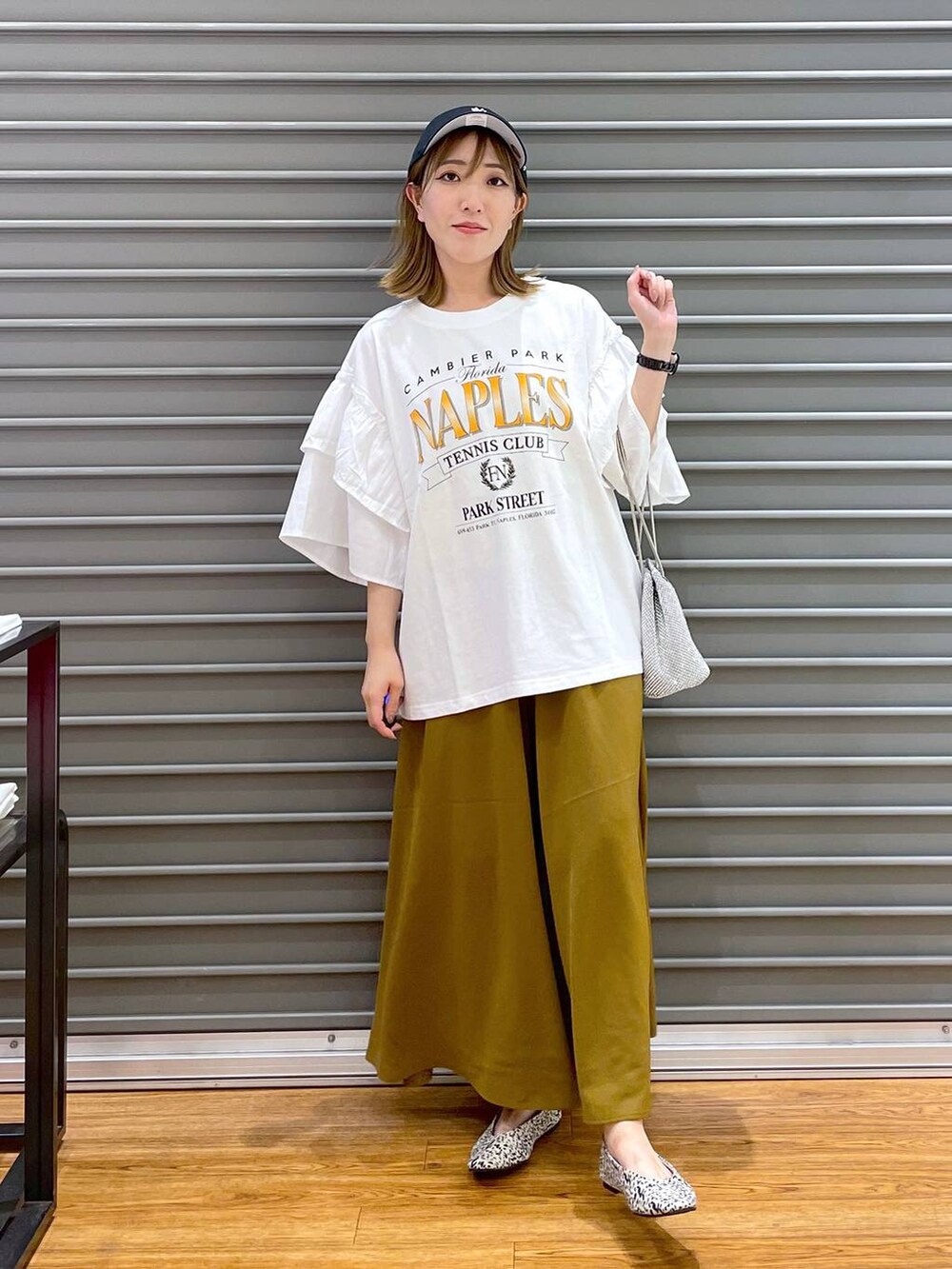 シルバー系のショルダーバッグ、グリーン系のその他パンツ、シルバー系のパンプスを着用したレディースの夏コーディネートの3枚目の写真