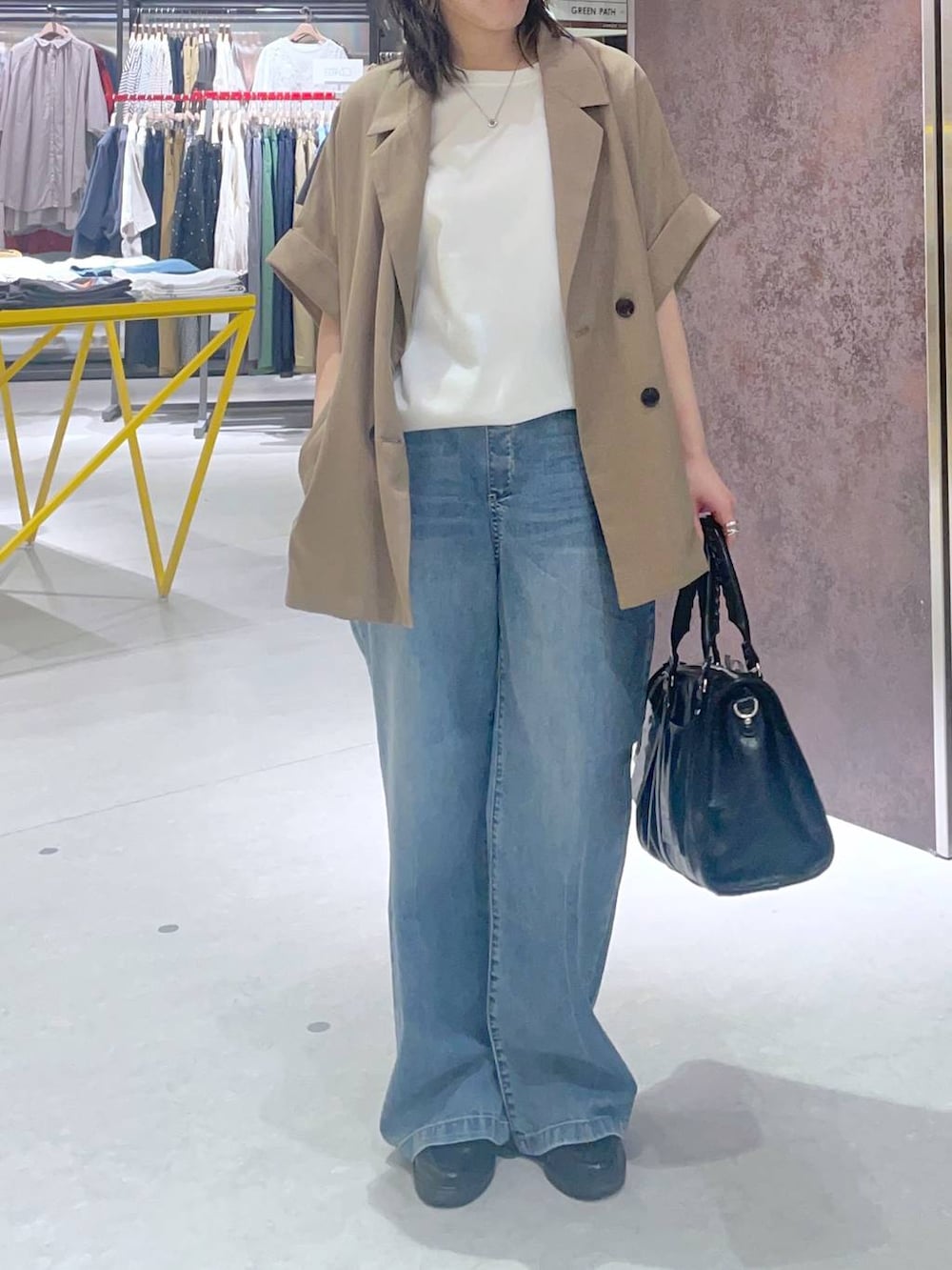 ホワイト系のTシャツ/カットソー、ブルー系のデニムパンツ、ベージュ系のテーラードジャケットを着用したレディースの春コーディネートの2枚目の写真