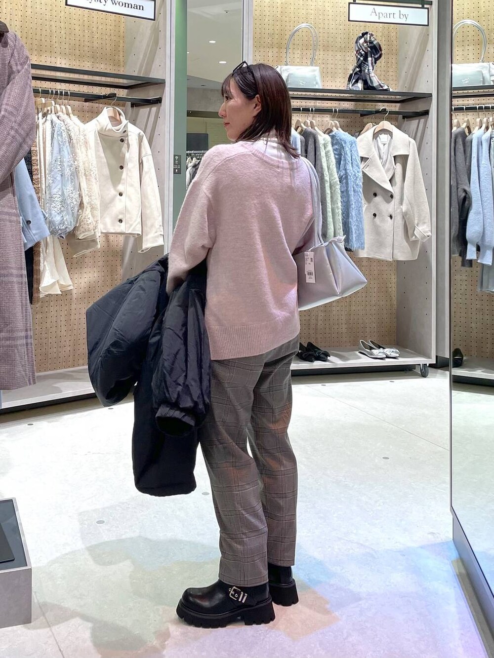 グレー系のその他パンツ、ホワイト系のTシャツ/カットソー、ブラック系のブーツを着用したレディースの冬コーディネートの2枚目の写真