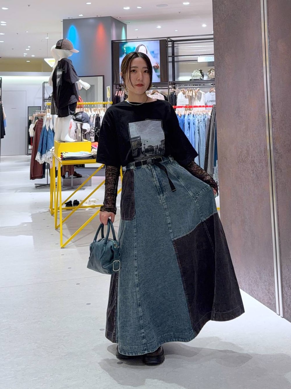 ブラウン系のブーツ、ブルー系のショルダーバッグ、ブラック系のTシャツ/カットソーを着用したレディースの秋コーディネートの2枚目の写真