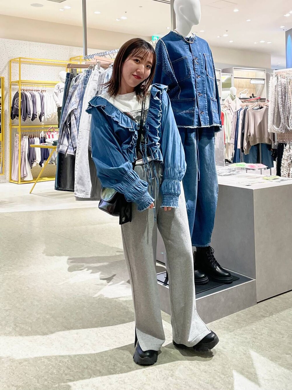 グレー系のスウェットパンツ、ブルー系のシャツ/ブラウス、ブラック系のショルダーバッグを着用したレディースの冬コーディネートの2枚目の写真