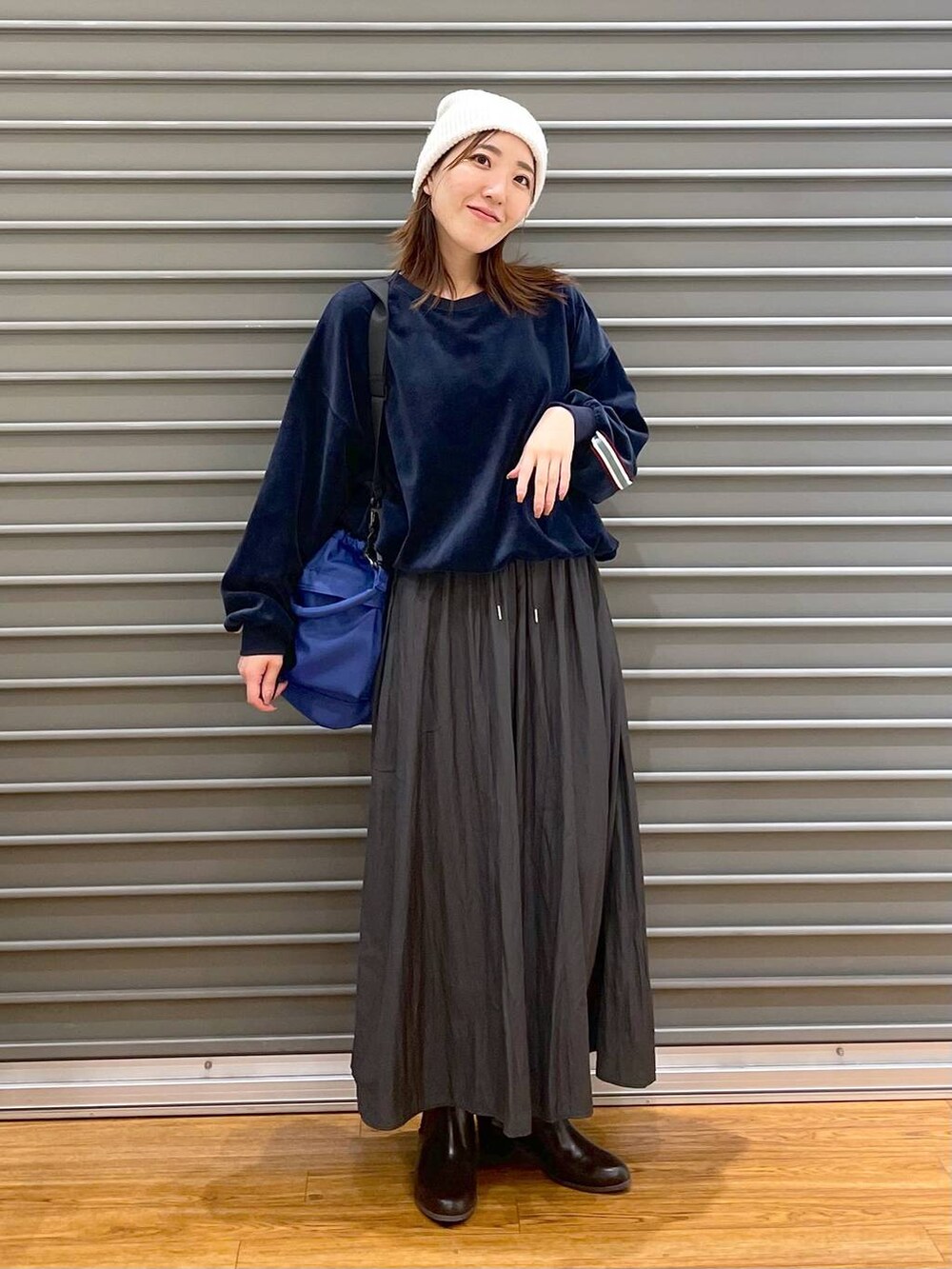 グレー系のその他パンツ、ブラウン系のブーツ、ブルー系のショルダーバッグを着用したレディースの冬コーディネートの2枚目の写真