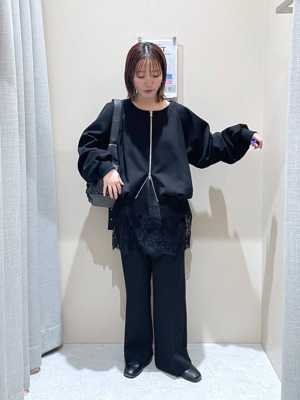 ブラック系のスウェット、ブラック系のその他パンツ、ブラック系のショルダーバッグを着用したレディースの冬コーディネートの4枚目の写真