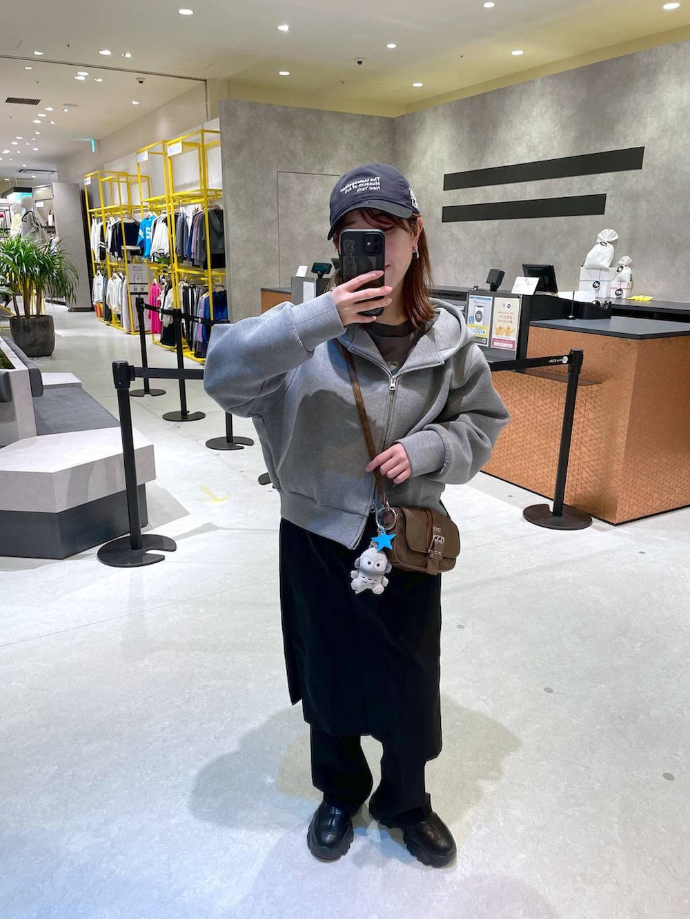 グリーン系のショルダーバッグ、ブラック系のその他パンツ、ブルー系のキャップを着用したレディースの冬コーディネートの3枚目の写真