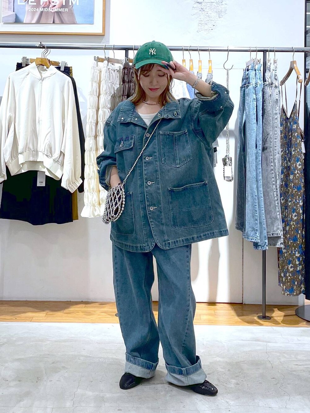 シルバー系のショルダーバッグ、ブルー系のデニムジャケット、ブラック系のバレエシューズを着用したレディースの秋コーディネートの2枚目の写真