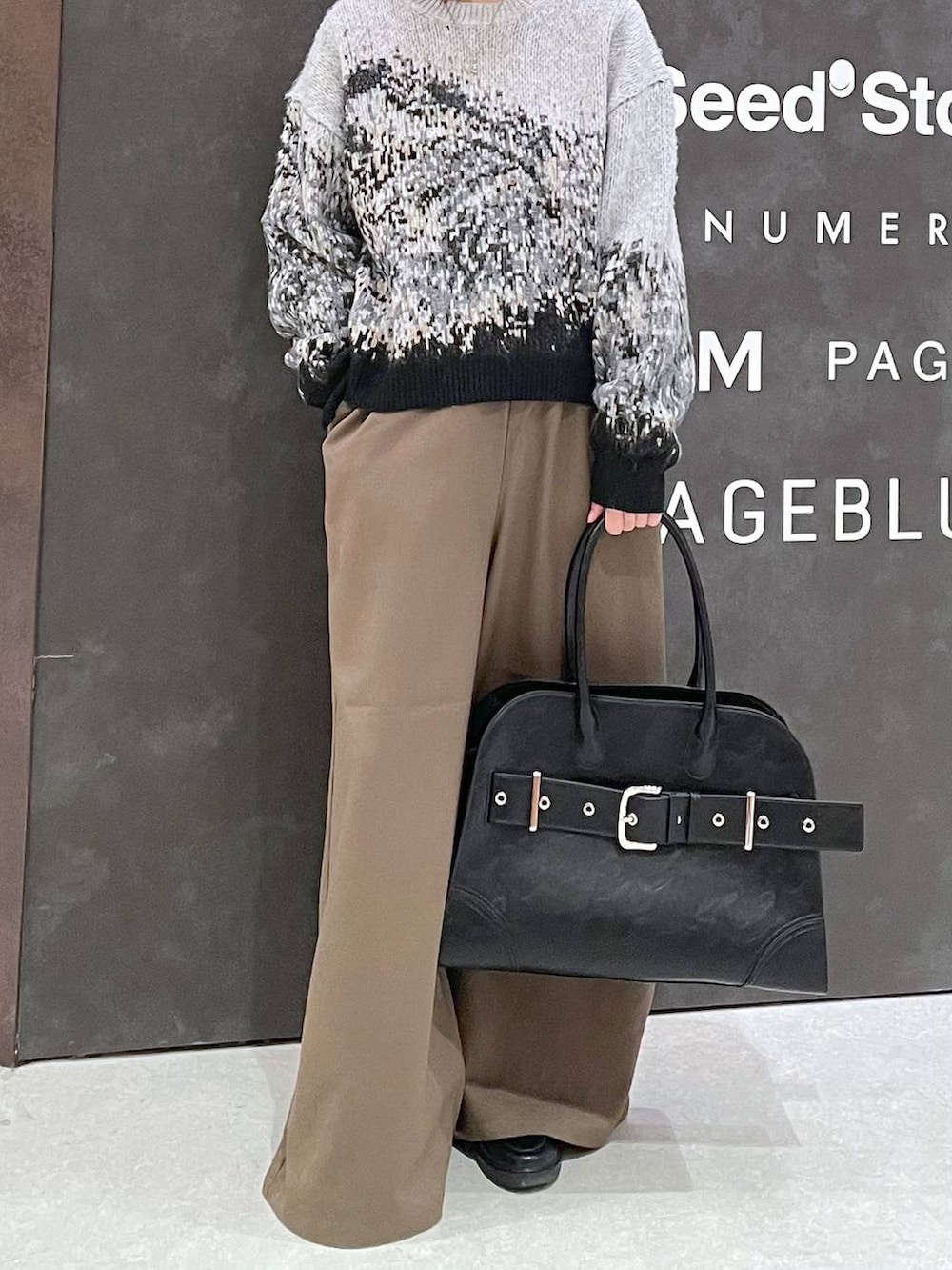 ブラウン系のその他パンツ、ブラック系のショルダーバッグ、グレー系のニット/セーターを着用したレディースの冬コーディネートの2枚目の写真