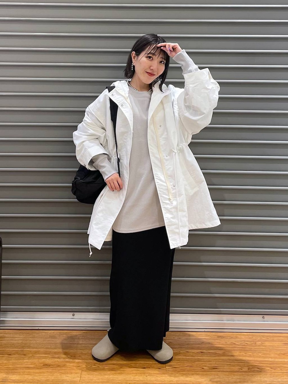 グレー系のスウェット、ブラック系のショルダーバッグ、ホワイト系のその他アウターを着用したレディースの春コーディネートの2枚目の写真