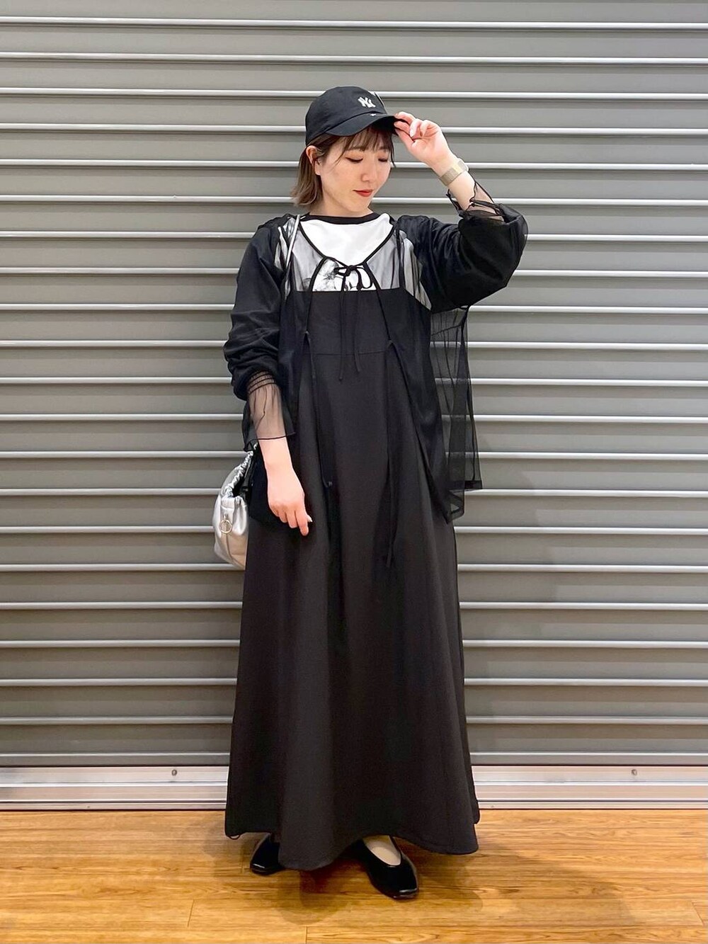 シルバー系のショルダーバッグ、ブラック系のワンピース、ブラック系のTシャツ/カットソーを着用したレディースの春コーディネートの2枚目の写真