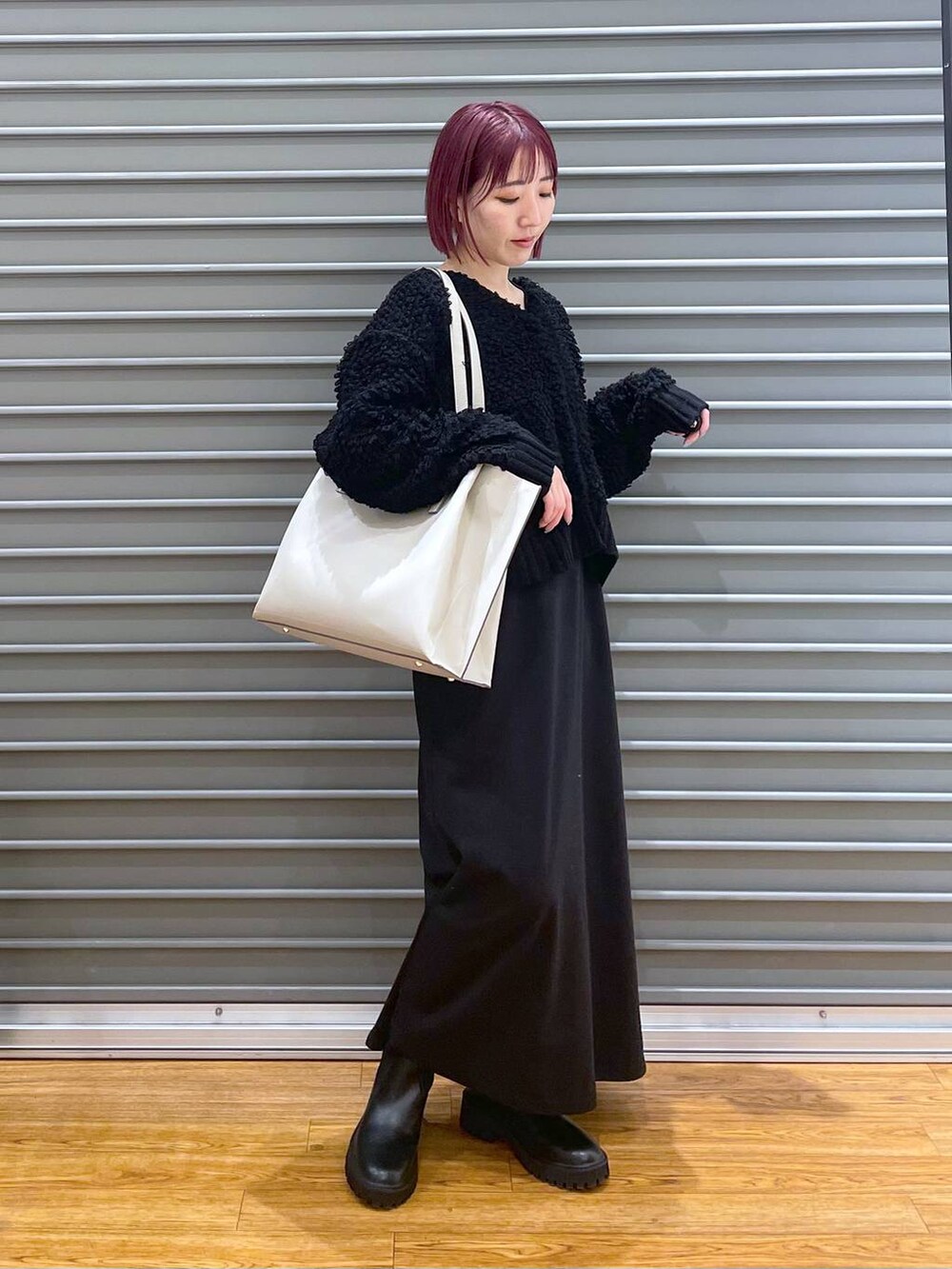 ブラック系のワンピース、ブラック系のブーツ、ベージュ系のトートバッグを着用したレディースの冬コーディネートの2枚目の写真