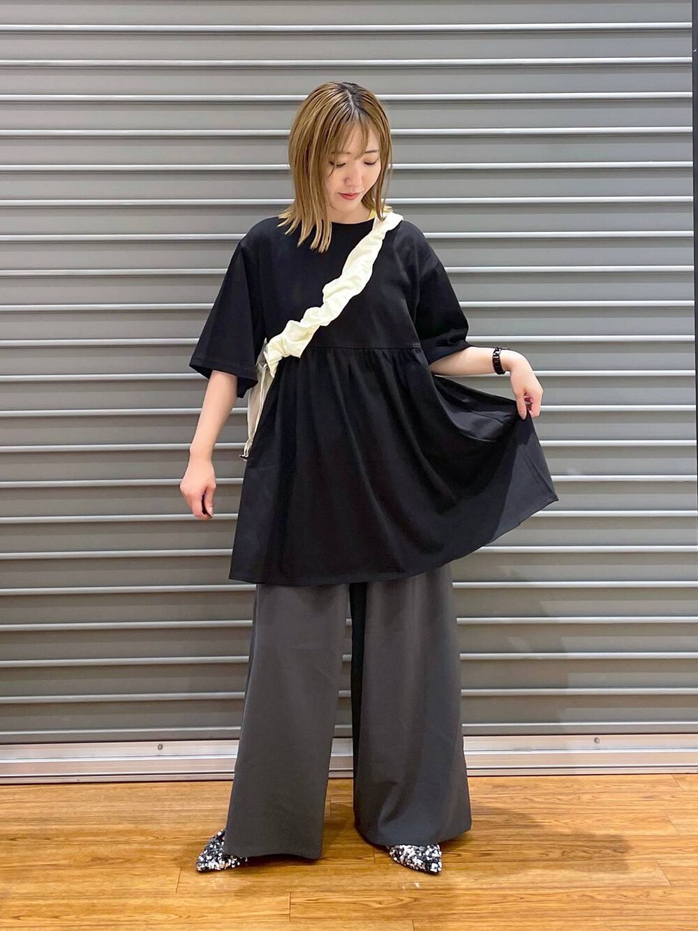 ホワイト系のショルダーバッグ、グレー系のその他パンツ、シルバー系のパンプスを着用したレディースの夏コーディネートの2枚目の写真