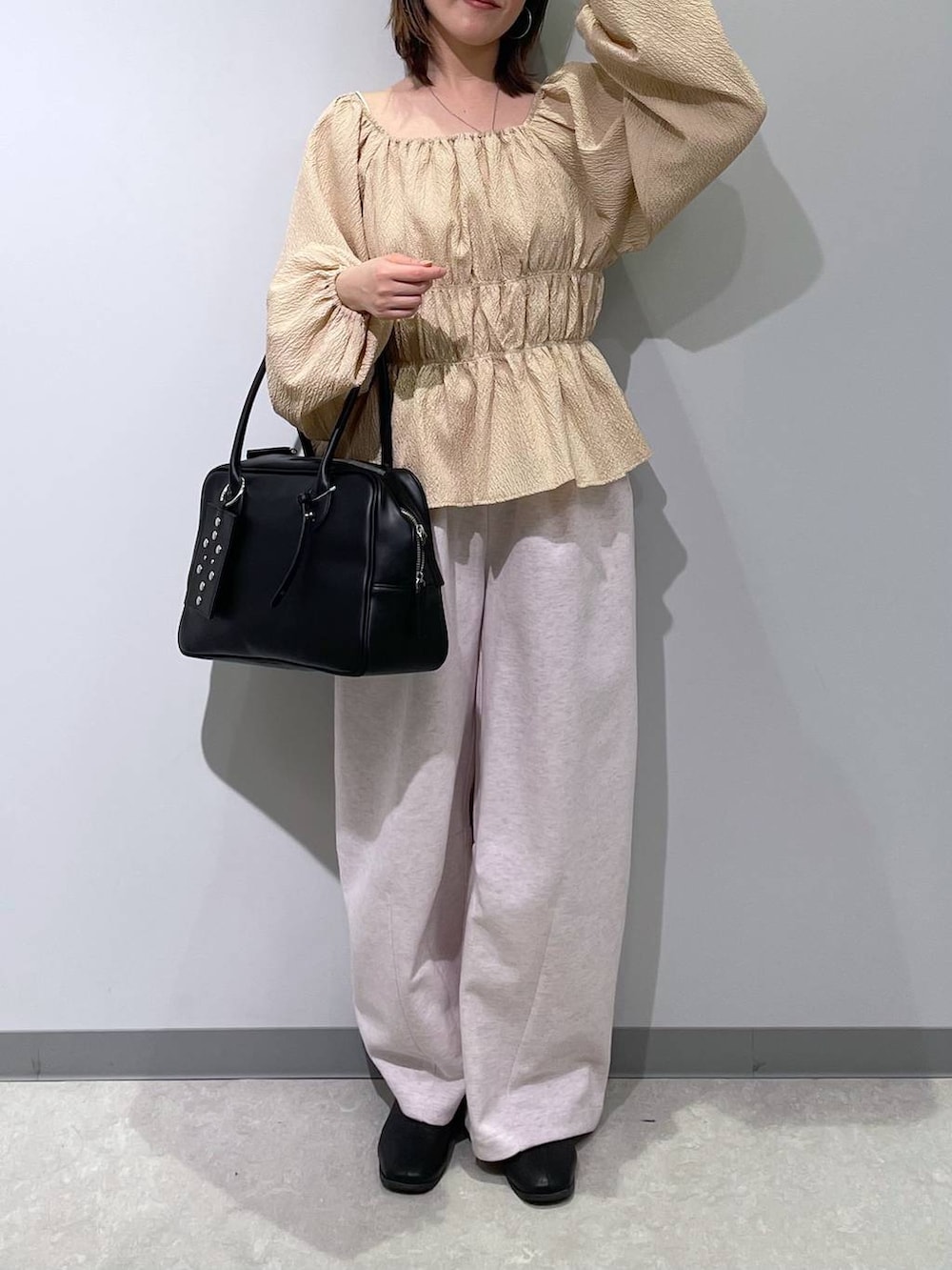 ピンク系のスウェットパンツ、ブラック系のボストンバッグ、ベージュ系のTシャツ/カットソーを着用したレディースの春コーディネートの2枚目の写真