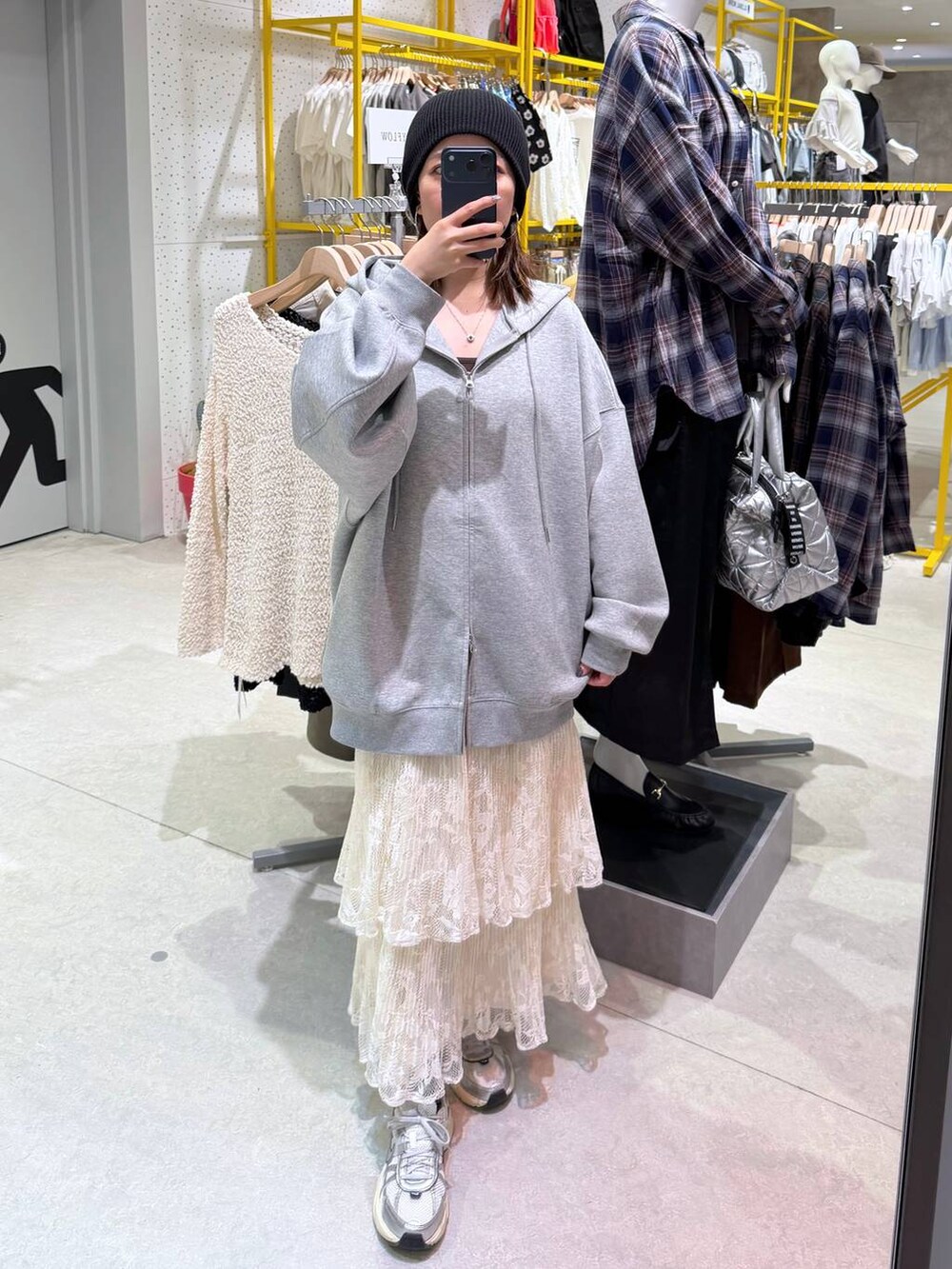 ホワイト系のスカート、グレー系のパーカーを着用したレディースの秋コーディネートの3枚目の写真