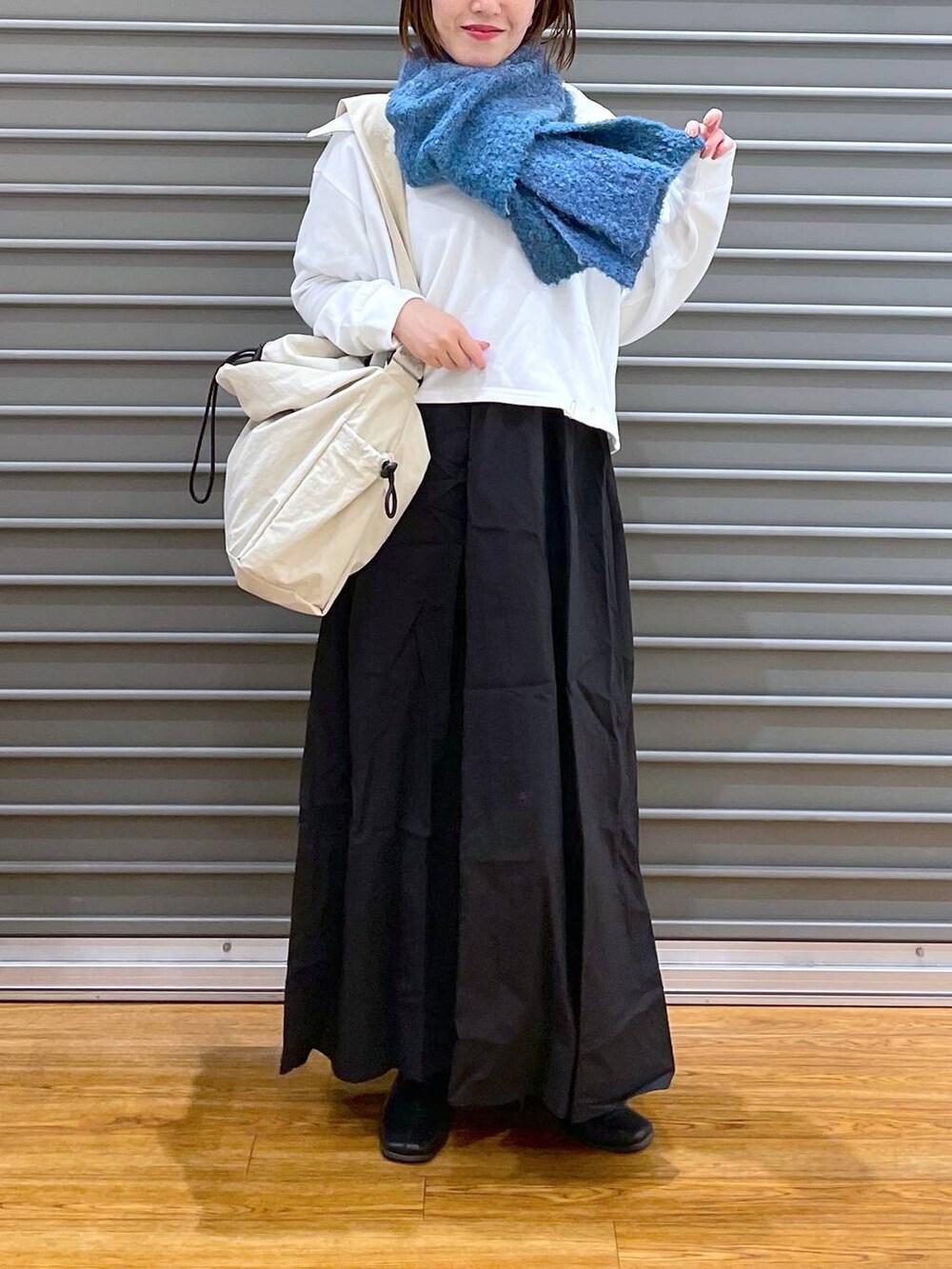 ホワイト系のワンピース、ホワイト系のショルダーバッグ、ブルー系のストール/ショールを着用したレディースの冬コーディネートの2枚目の写真