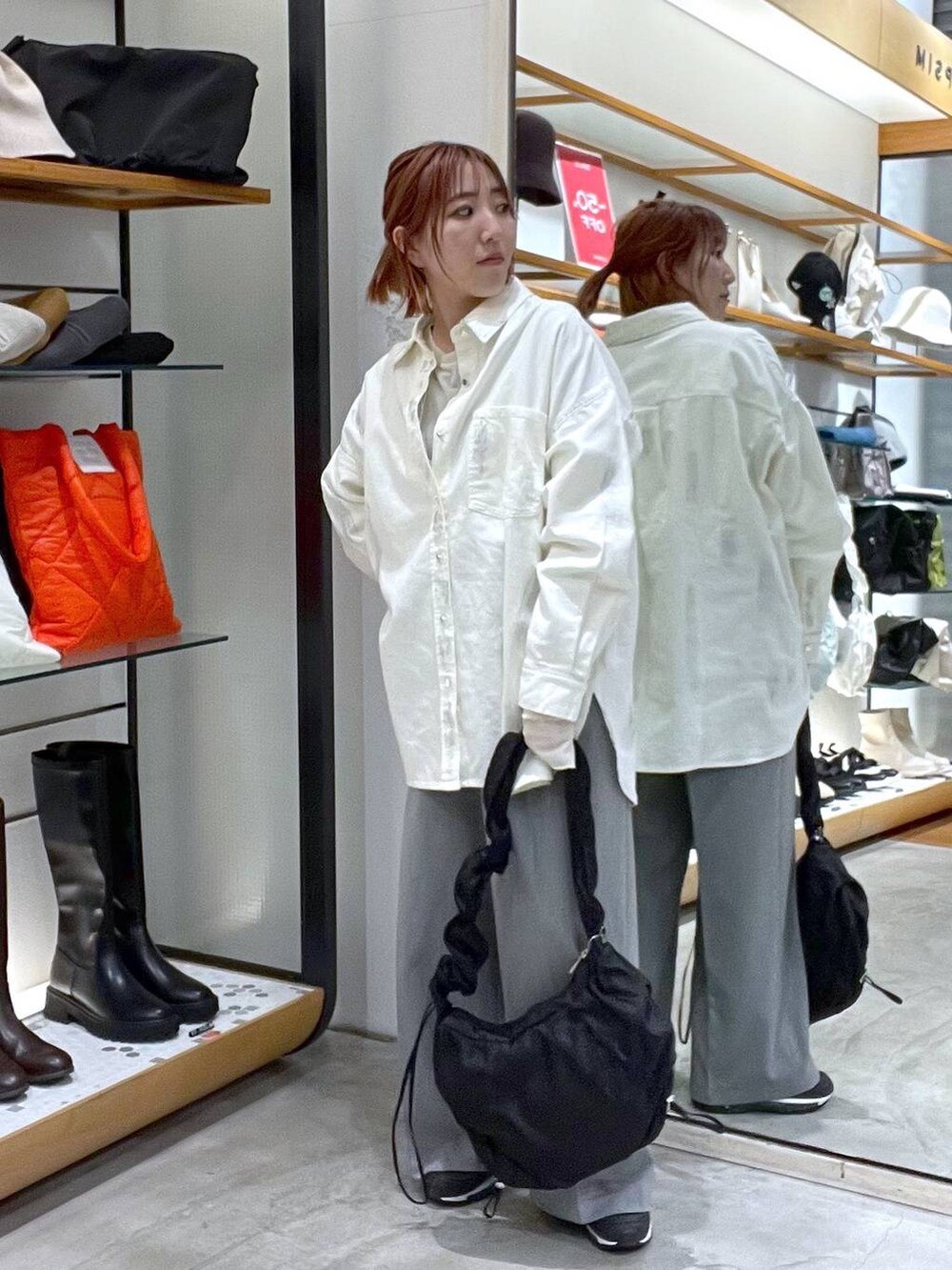 グリーン系のTシャツ/カットソー、ホワイト系のシャツ/ブラウス、ブラック系のショルダーバッグを着用したレディースの春コーディネートの3枚目の写真