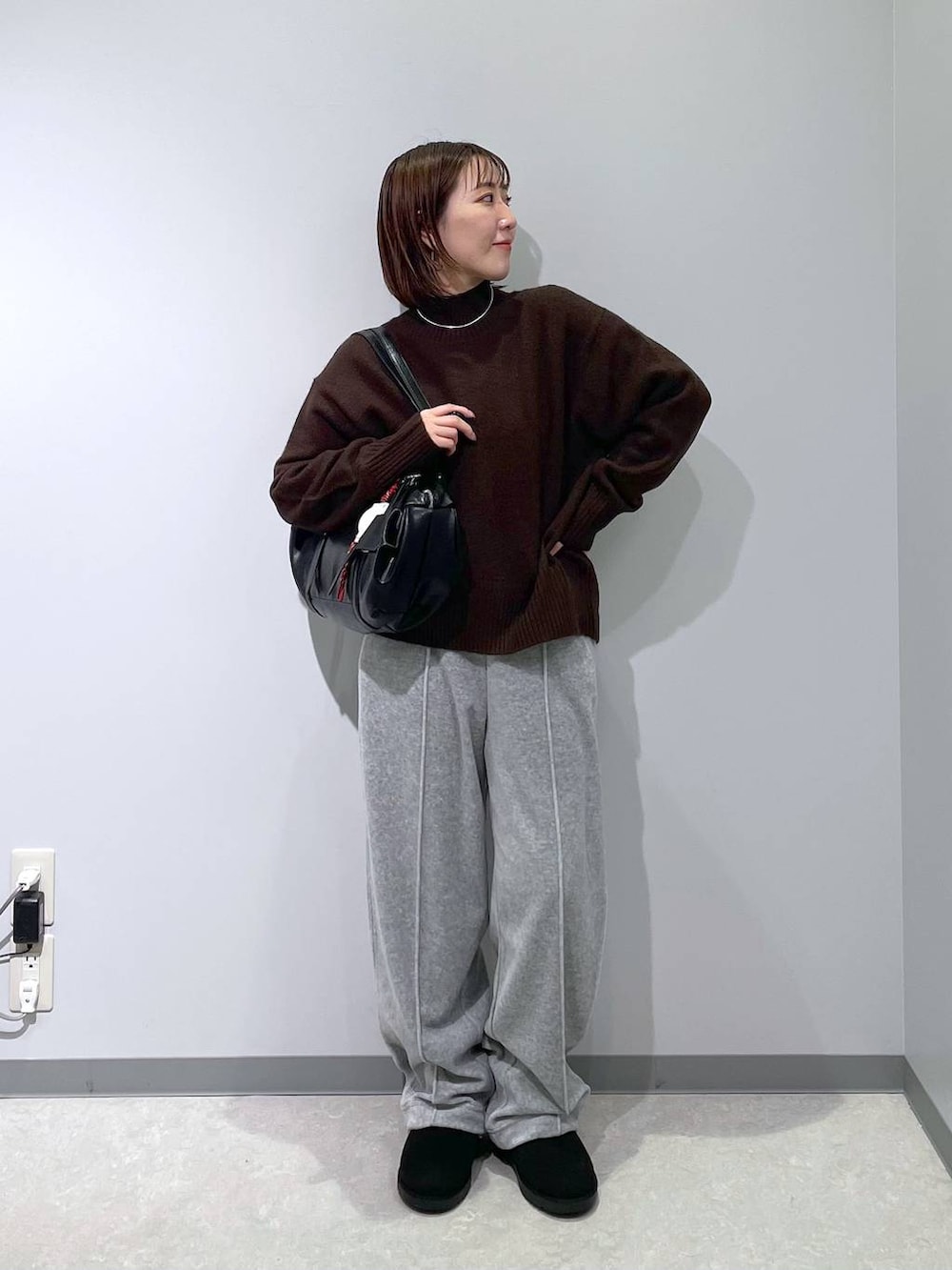 グレー系のその他パンツ、ブラウン系のニット/セーター、ブラック系のブーツを着用したレディースの冬コーディネートの3枚目の写真