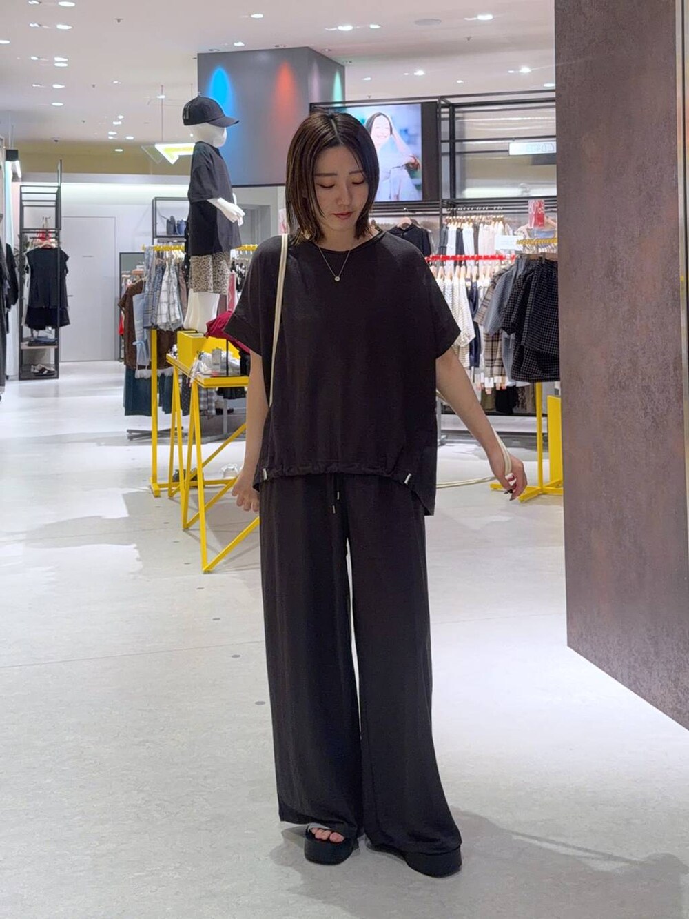 グレー系のTシャツ/カットソー、シルバー系のサンダル、ホワイト系のバックパック/リュックを着用したレディースの夏コーディネートの2枚目の写真