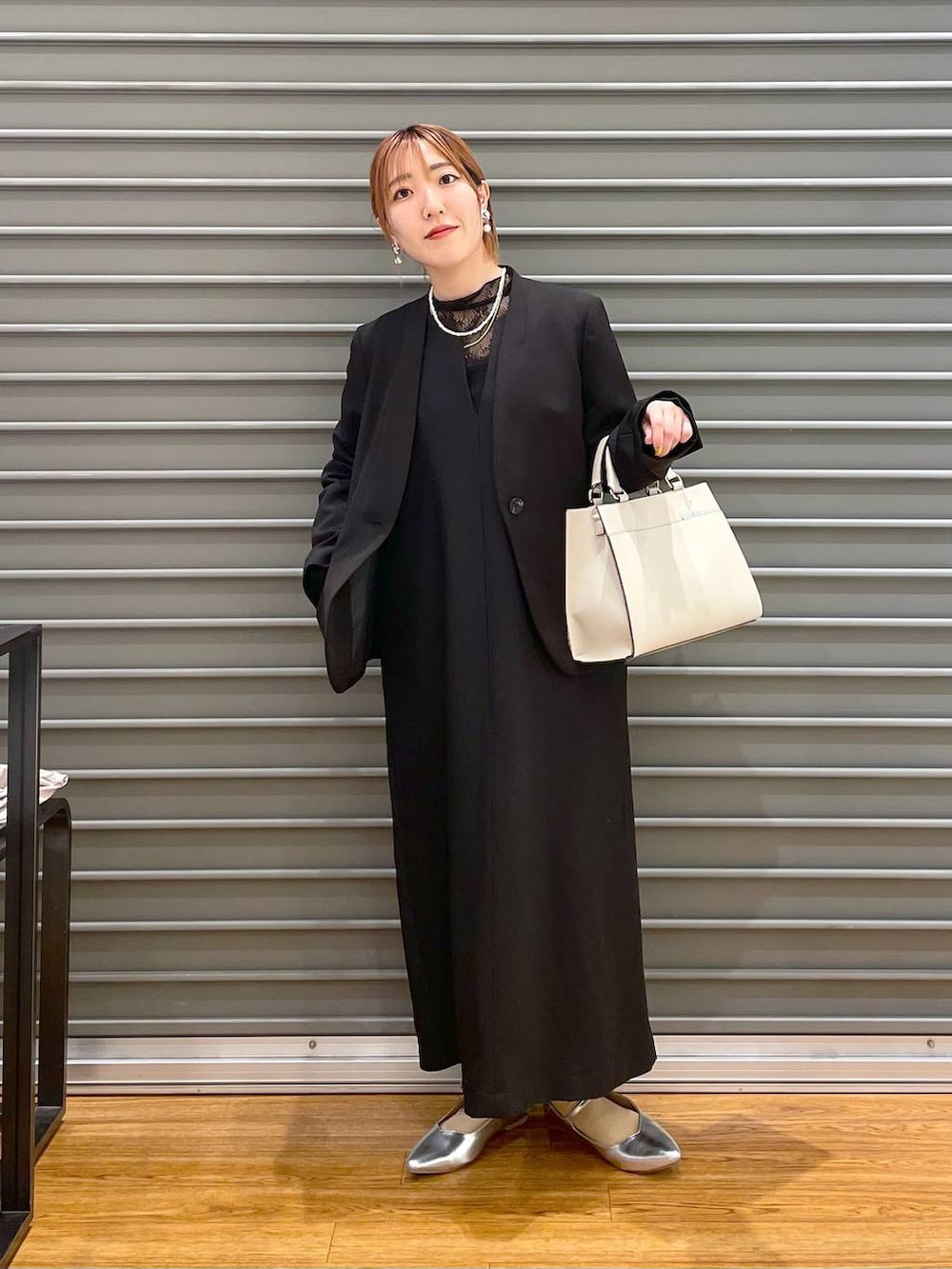 ブラック系のノーカラージャケット、ホワイト系のショルダーバッグ、グレー系のパンプスを着用したレディースの冬コーディネートの3枚目の写真