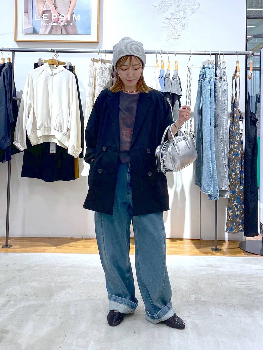 ブルー系のデニムパンツ、シルバー系のボストンバッグ、ブラック系のバレエシューズを着用したレディースの秋コーディネートの3枚目の写真