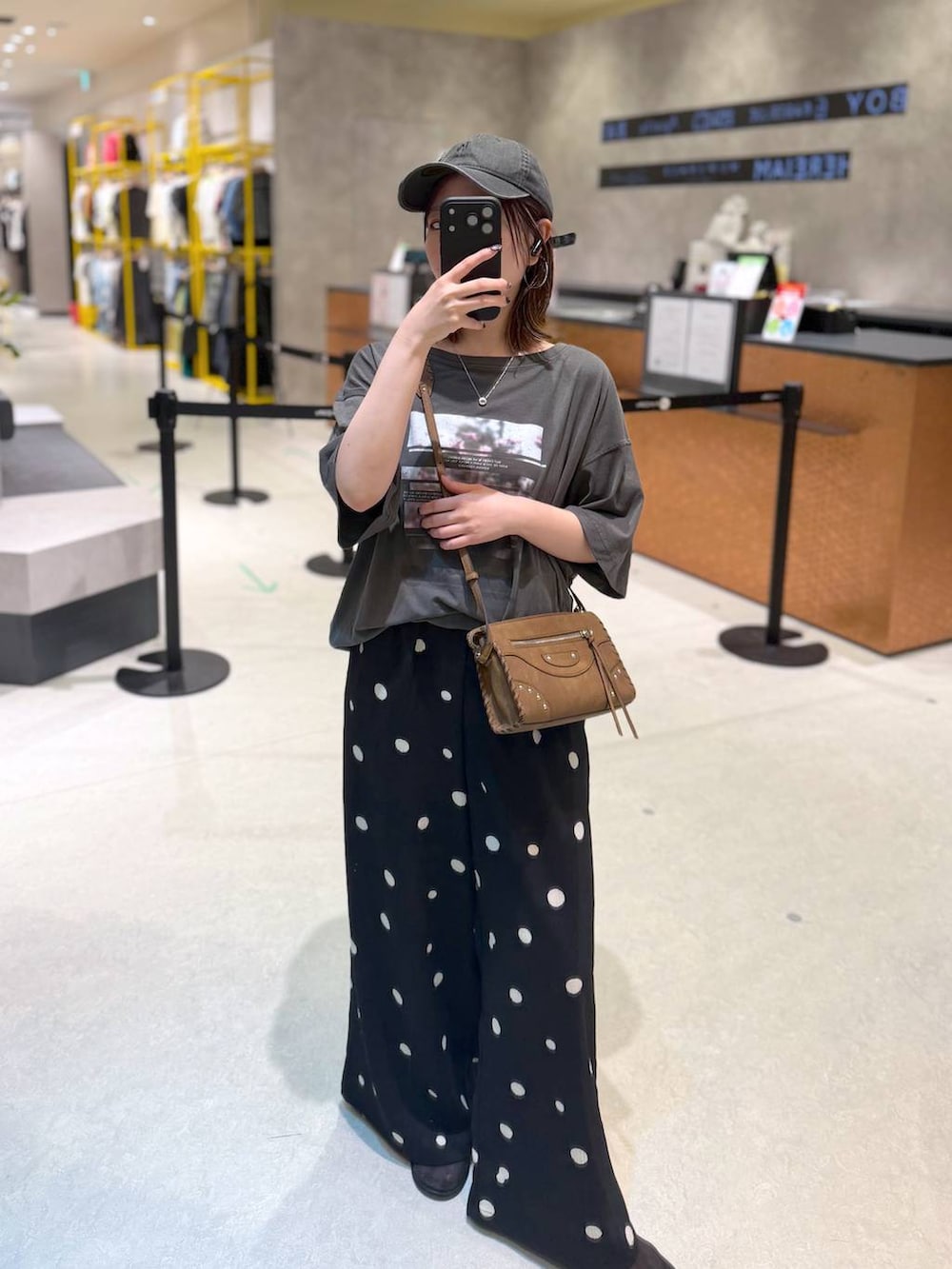 ブラック系のその他パンツ、グレー系のTシャツ/カットソー、ブラウン系のショルダーバッグを着用したレディースの夏コーディネートの3枚目の写真