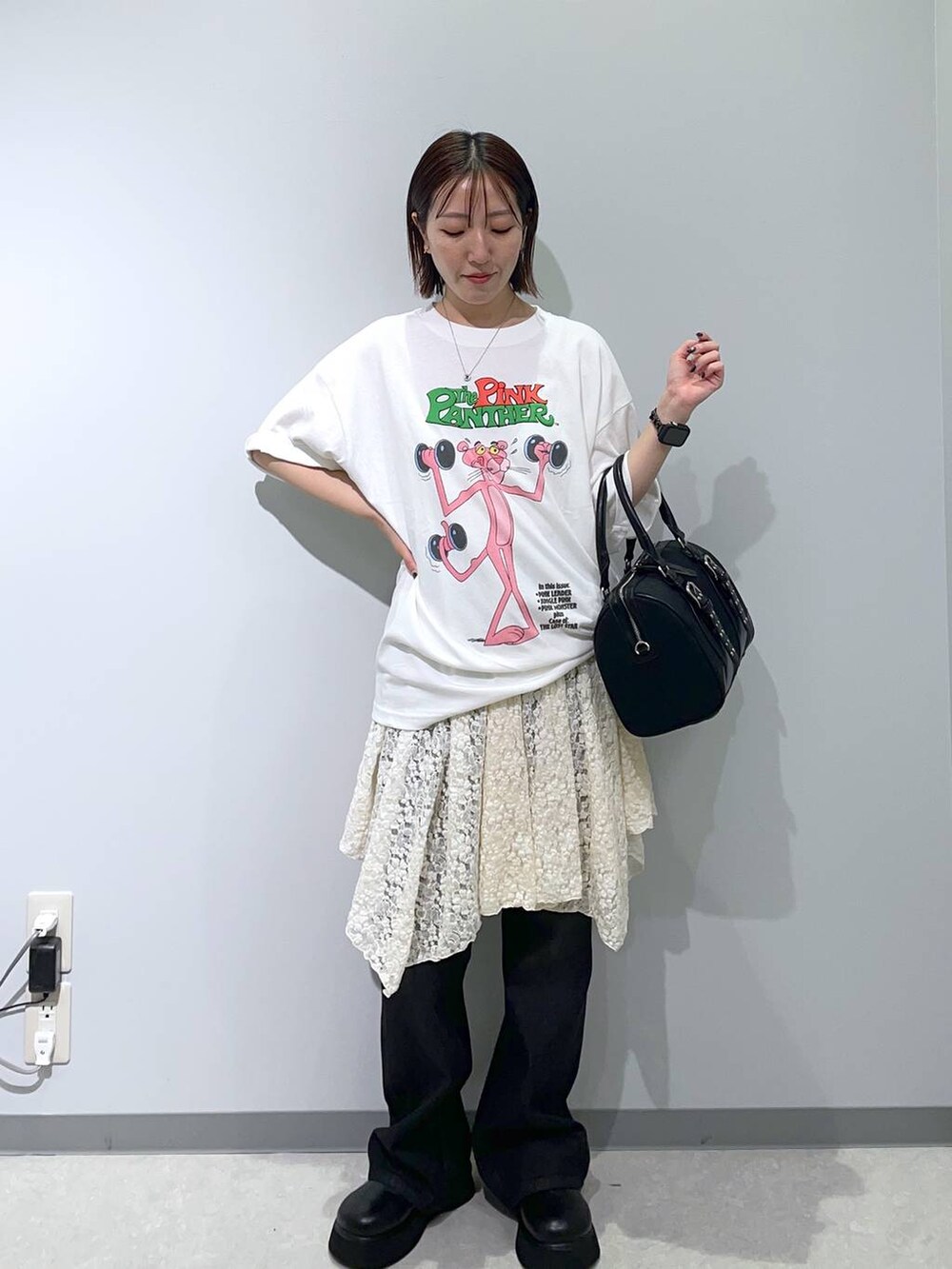 ブラック系のデニムパンツ、グレー系のTシャツ/カットソー、ブラック系のボストンバッグを着用したレディースの夏コーディネートの2枚目の写真
