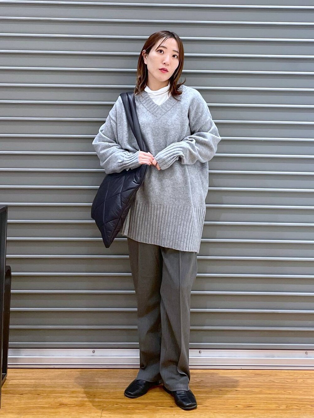 グレー系のその他パンツ、ブラック系のトートバッグ、グレー系のニット/セーターを着用したレディースの冬コーディネートの3枚目の写真