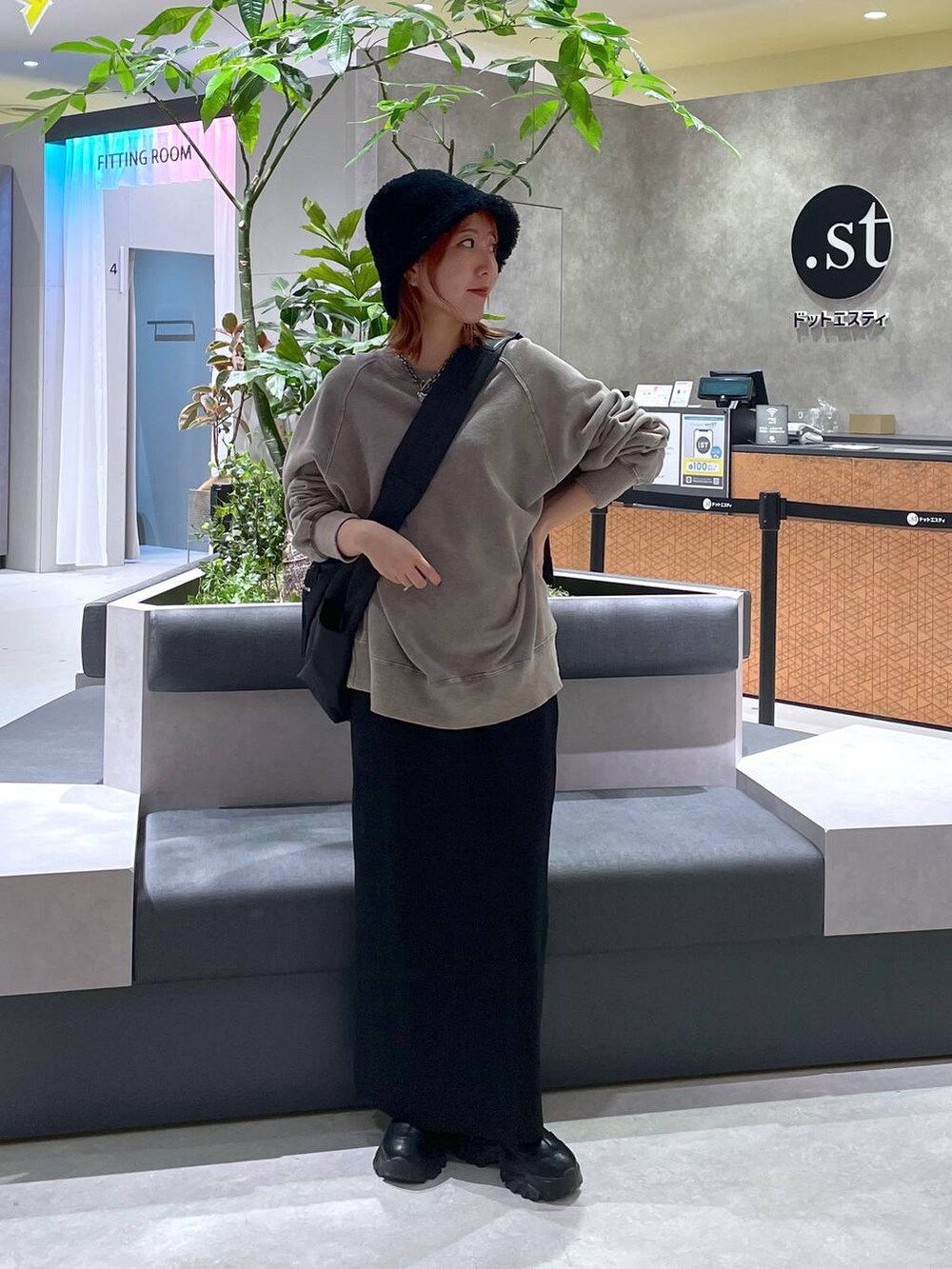 ブラック系のスカート、ブラック系のショルダーバッグ、ブラック系のスウェットを着用したレディースの冬コーディネートの2枚目の写真