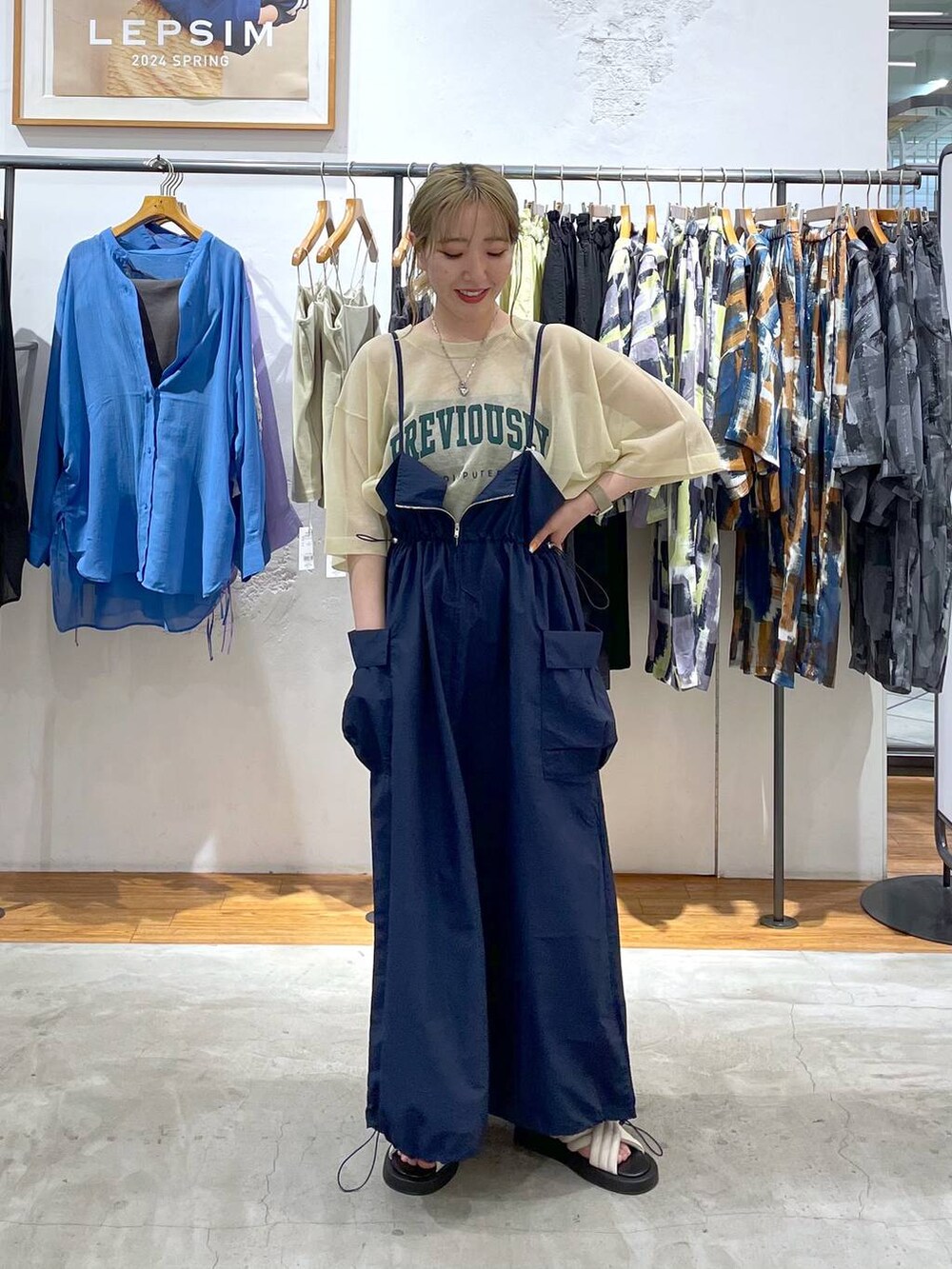 ブルー系のワンピース、ベージュ系のその他トップス、ホワイト系のサンダルを着用したレディースの春コーディネートの2枚目の写真