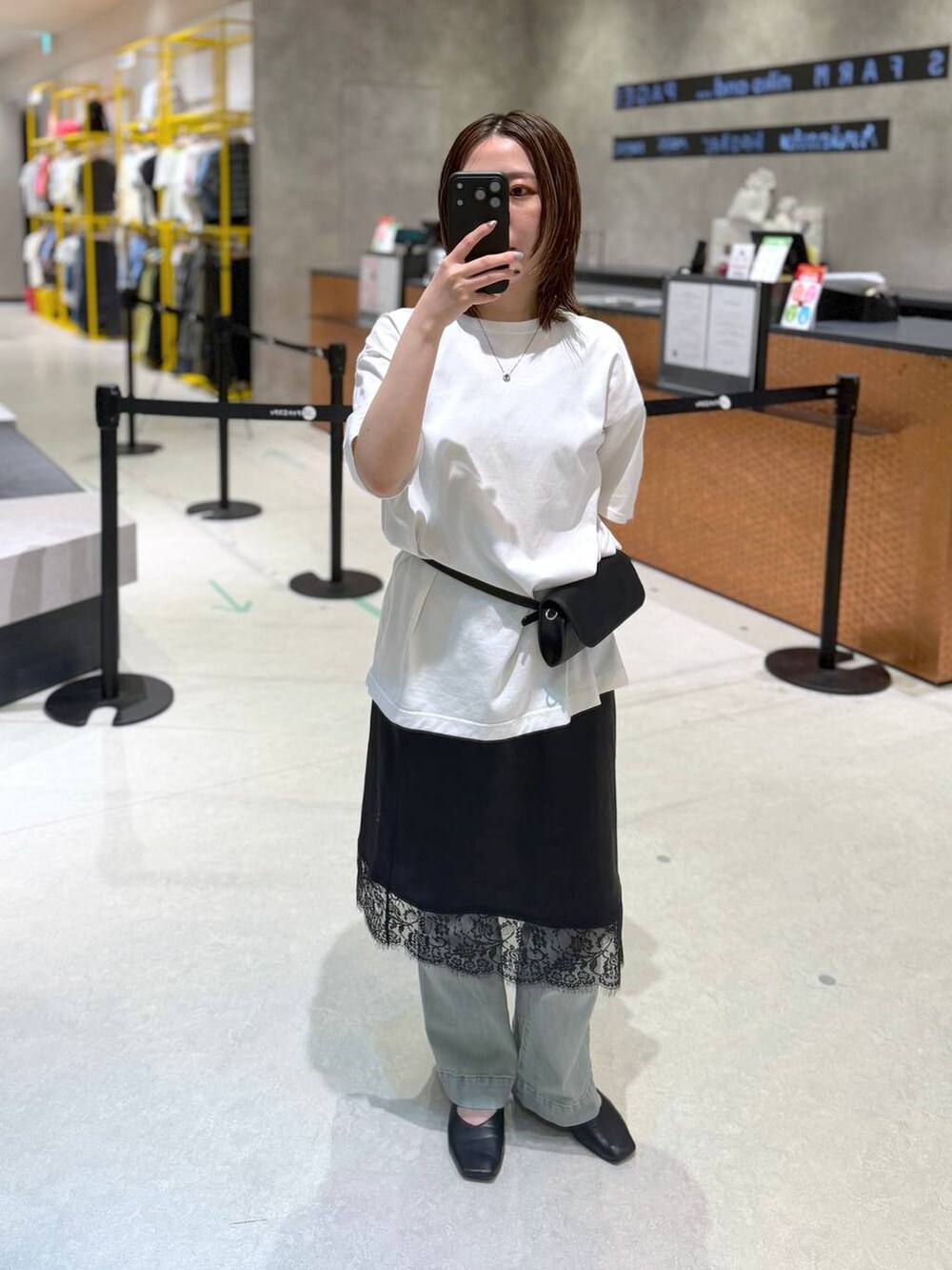 ブラック系のボディバッグ/ウエストポーチ、ホワイト系のTシャツ/カットソー、ブラック系のスカートを着用したレディースの夏コーディネートの3枚目の写真