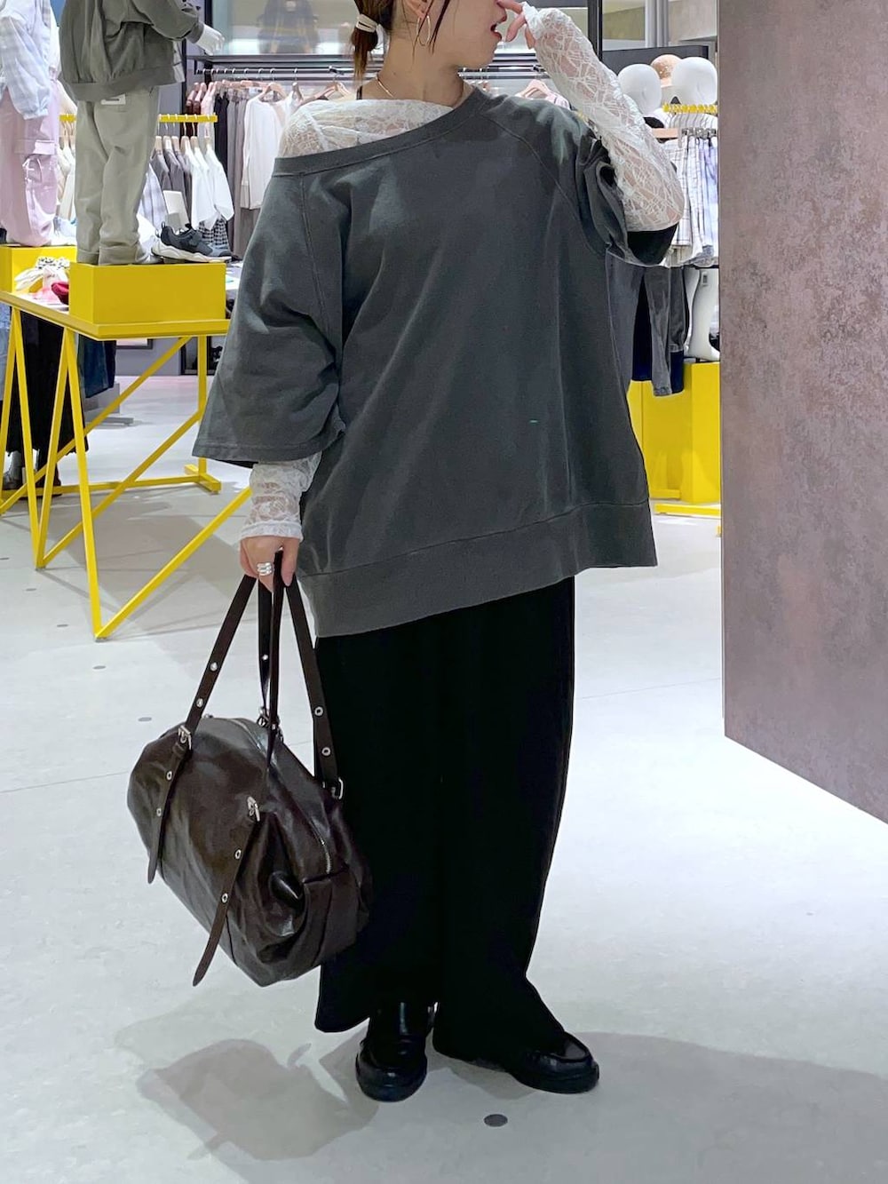 ブラック系のスラックス、ホワイト系のTシャツ/カットソー、ブラウン系のボストンバッグを着用したレディースの春コーディネートの2枚目の写真