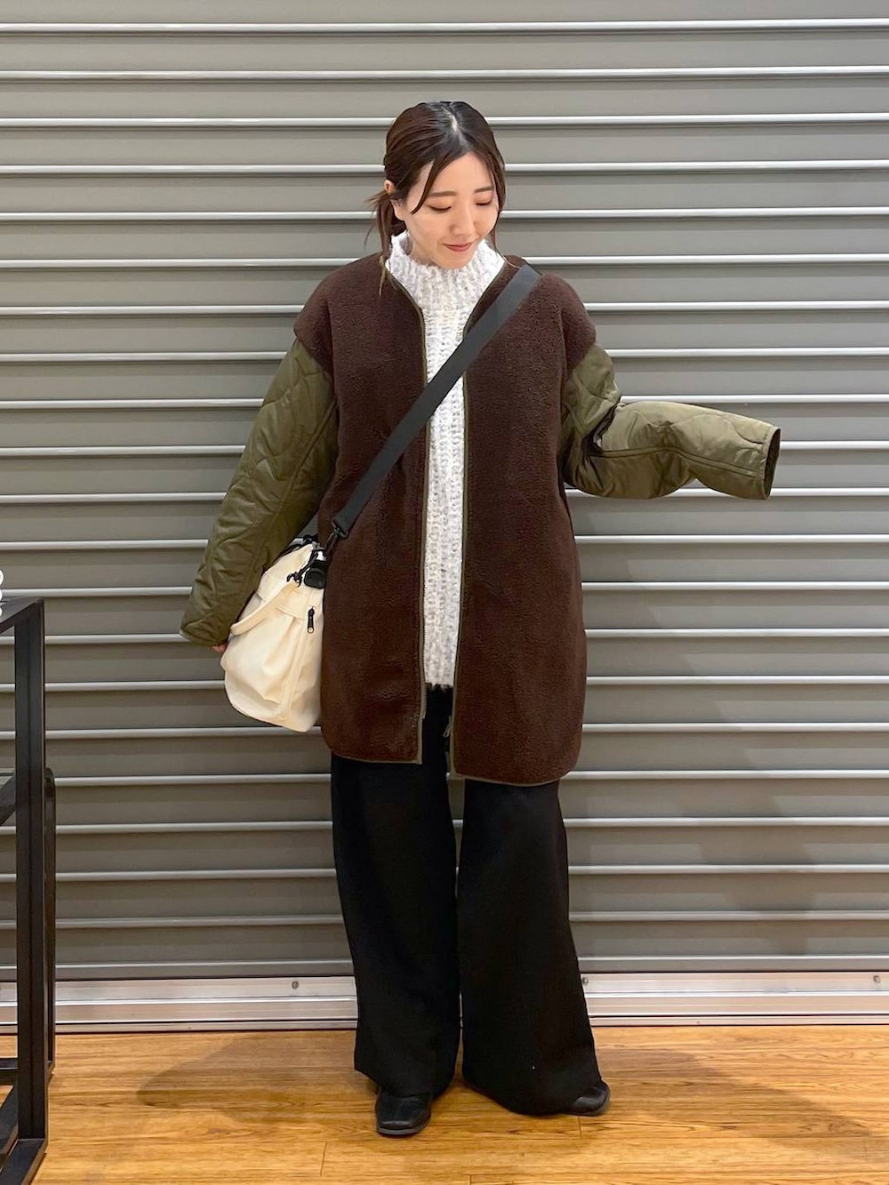 ブラック系のその他パンツ、ホワイト系のショルダーバッグ、グリーン系のマタニティウェア/グッズを着用したレディースの冬コーディネートの2枚目の写真