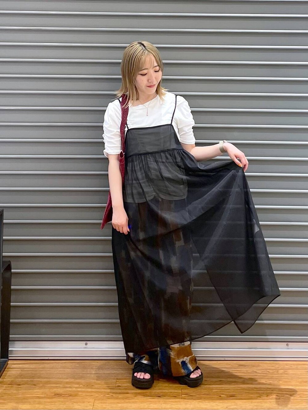 ピンク系のトートバッグ、ブラック系のワンピース、ブルー系のその他パンツを着用したレディースの夏コーディネートの2枚目の写真