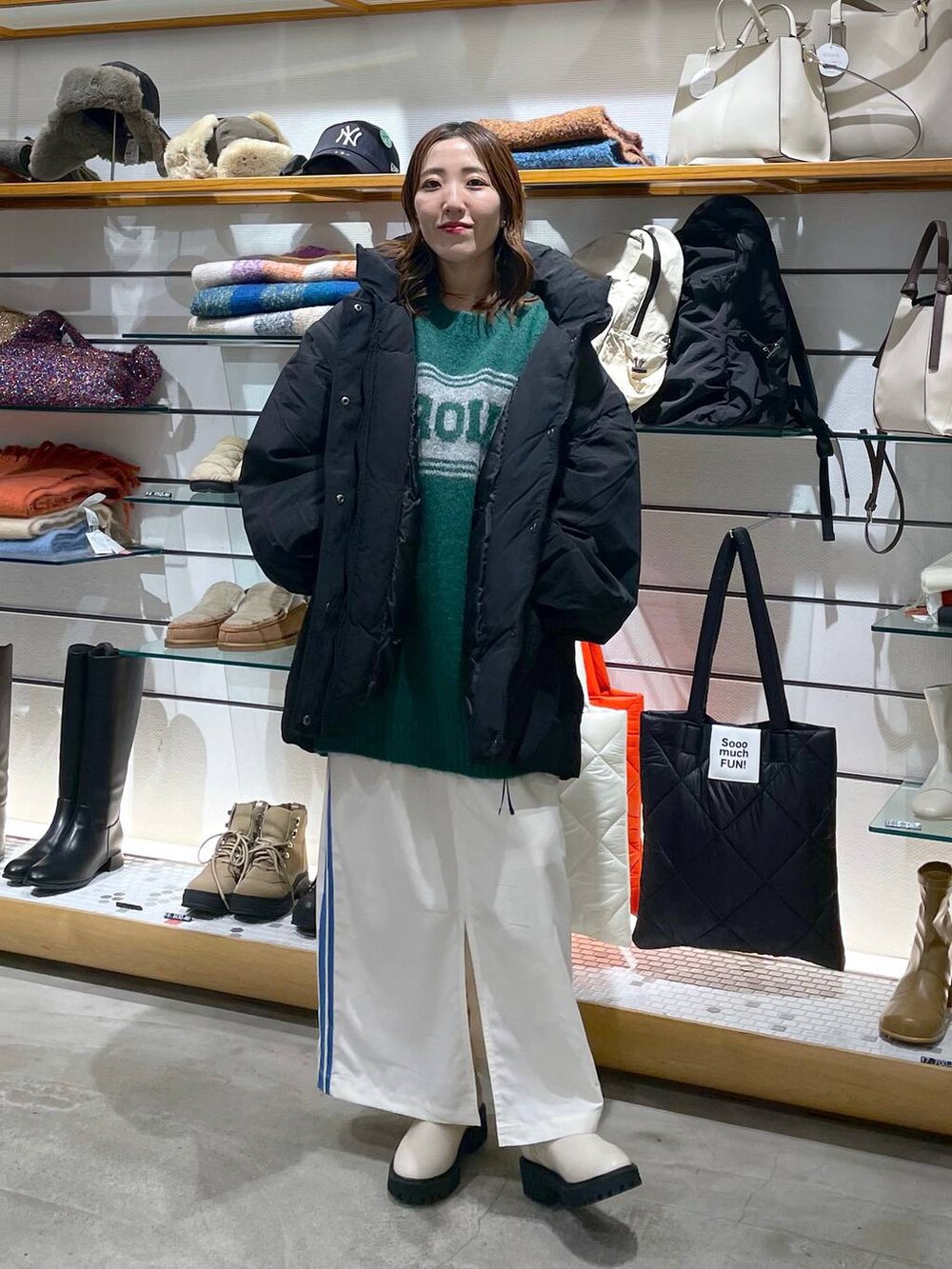 ブラック系のその他アウター、ホワイト系のブーツ、ホワイト系のスカートを着用したレディースの冬コーディネートの2枚目の写真