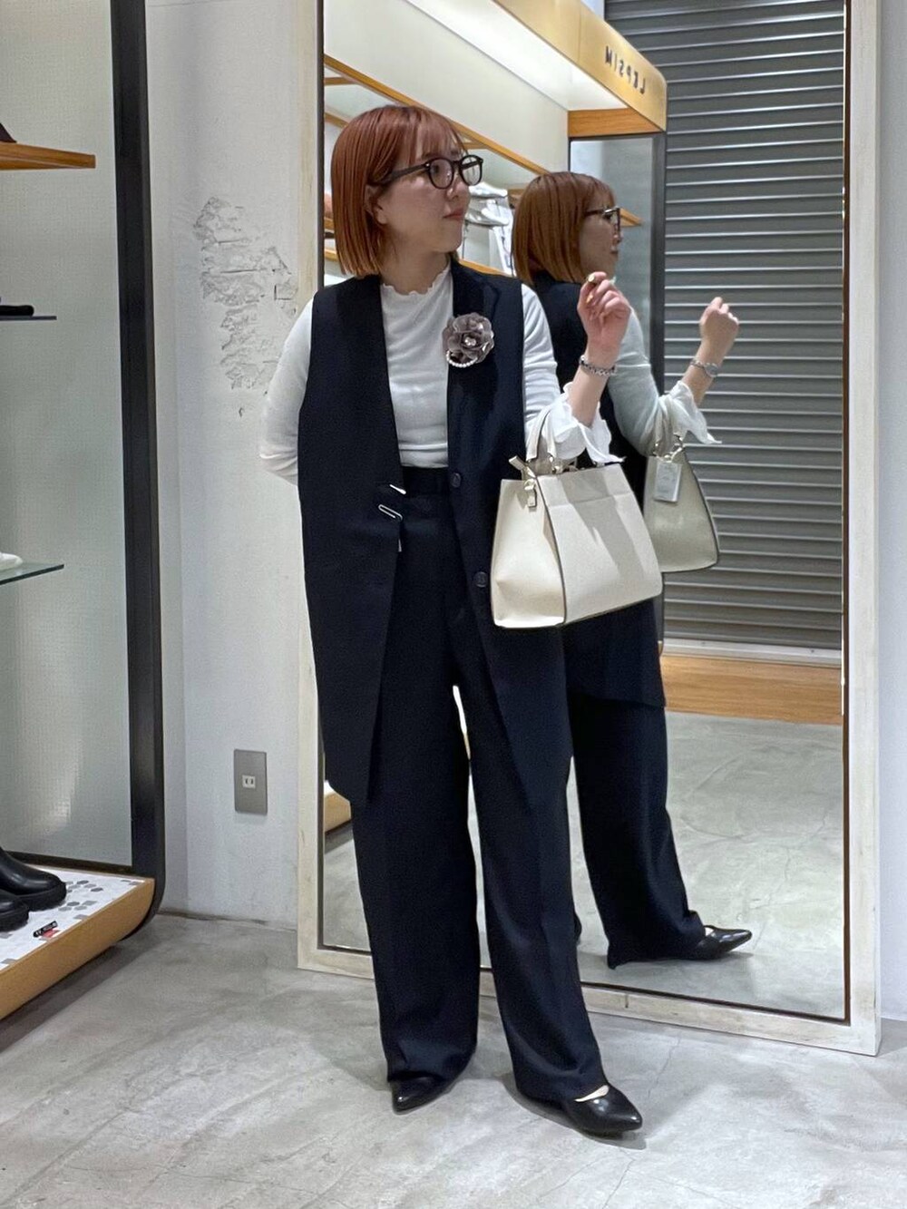 ホワイト系のTシャツ/カットソー、ホワイト系のショルダーバッグ、ブラック系のパンプスを着用したレディースの冬コーディネートの4枚目の写真