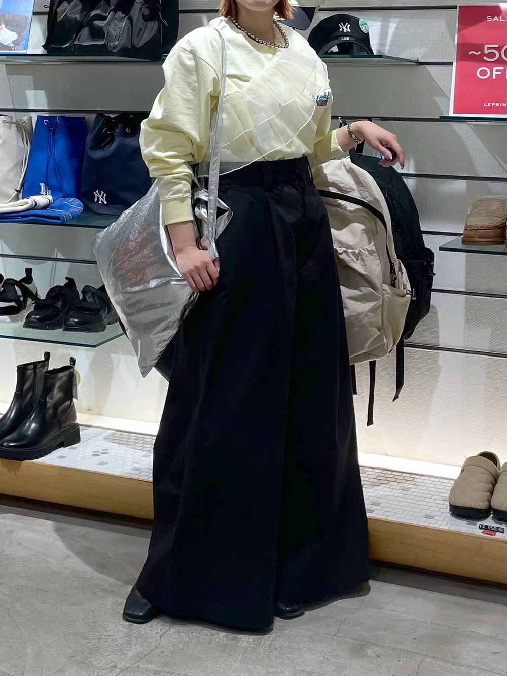 シルバー系のトートバッグ、ブラック系のチノパンツ、イエロー系のTシャツ/カットソーを着用したレディースの春コーディネートの3枚目の写真