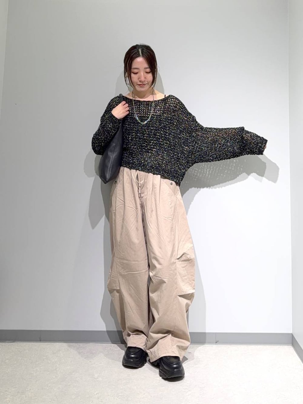 ブラック系のニット/セーター、ブラック系のトートバッグ、ブラック系のローファーを着用したレディースの夏コーディネートの2枚目の写真
