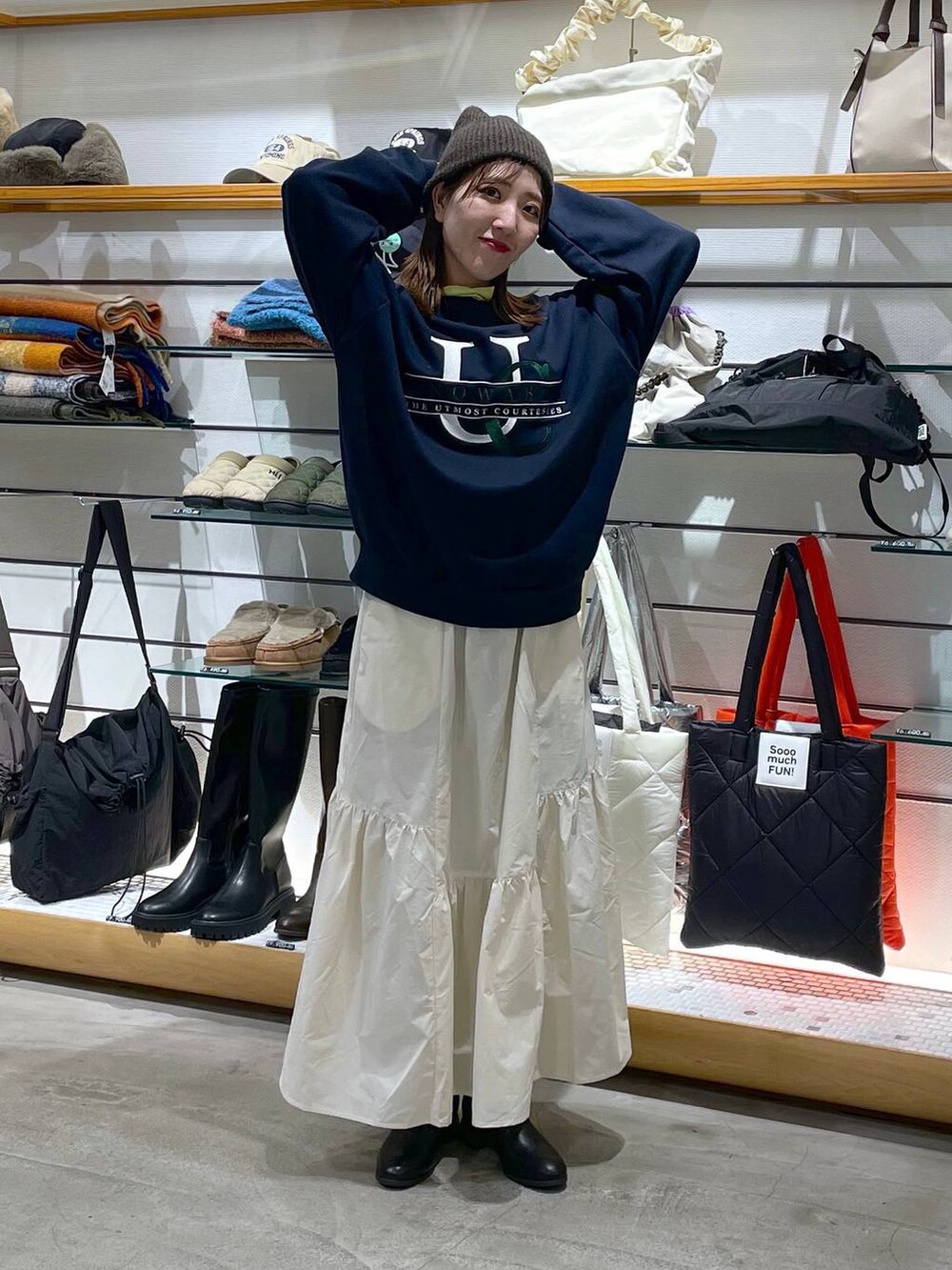 ホワイト系のスカート、ブラック系のブーツ、イエロー系のTシャツ/カットソーを着用したレディースの冬コーディネートの3枚目の写真