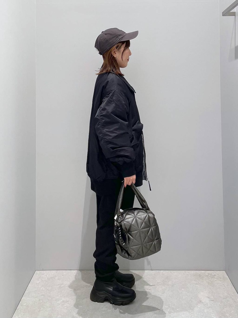 ブラック系のブルゾン、ブラック系のトートバッグ、ブラック系のカーゴパンツを着用したレディースの冬コーディネートの4枚目の写真