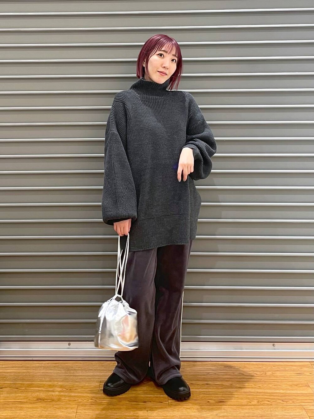 ブラック系のブーツ、グレー系のTシャツ/カットソー、シルバー系のショルダーバッグを着用したレディースの冬コーディネートの2枚目の写真