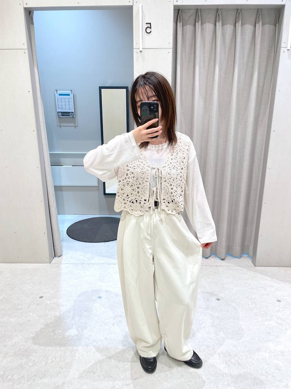 ホワイト系のその他パンツ、ベージュ系のベスト、シルバー系のネックレスを着用したレディースの春コーディネートの2枚目の写真