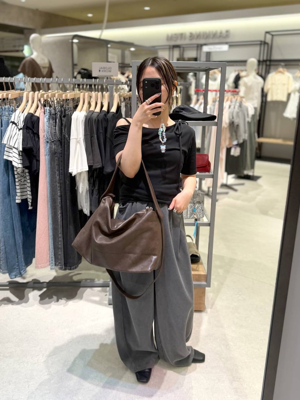 ブラウン系のショルダーバッグ、グレー系のスウェットパンツ、ブラック系のTシャツ/カットソーを着用したレディースの夏コーディネートの2枚目の写真